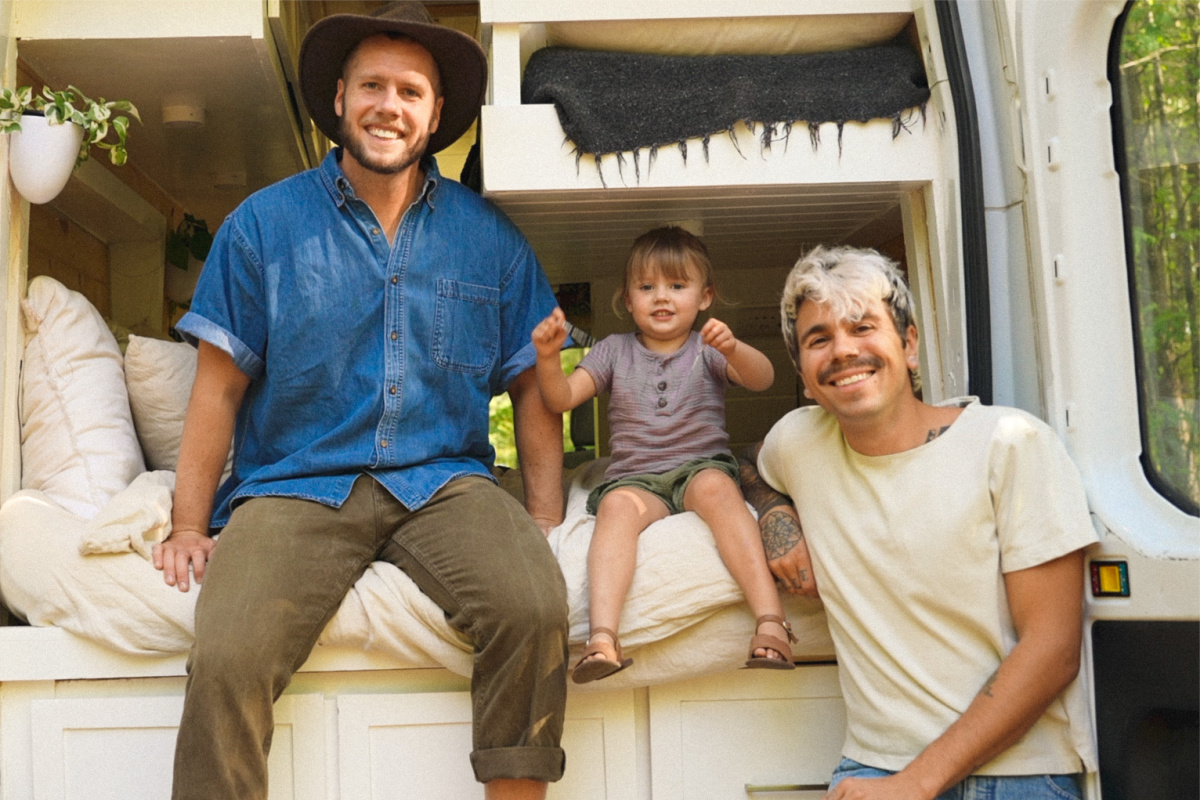 two men and a girl posing in a camper