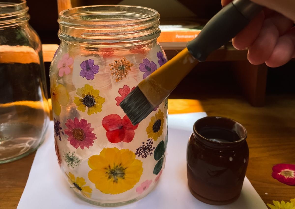 brush painting pressed flowers onto flower lanterns