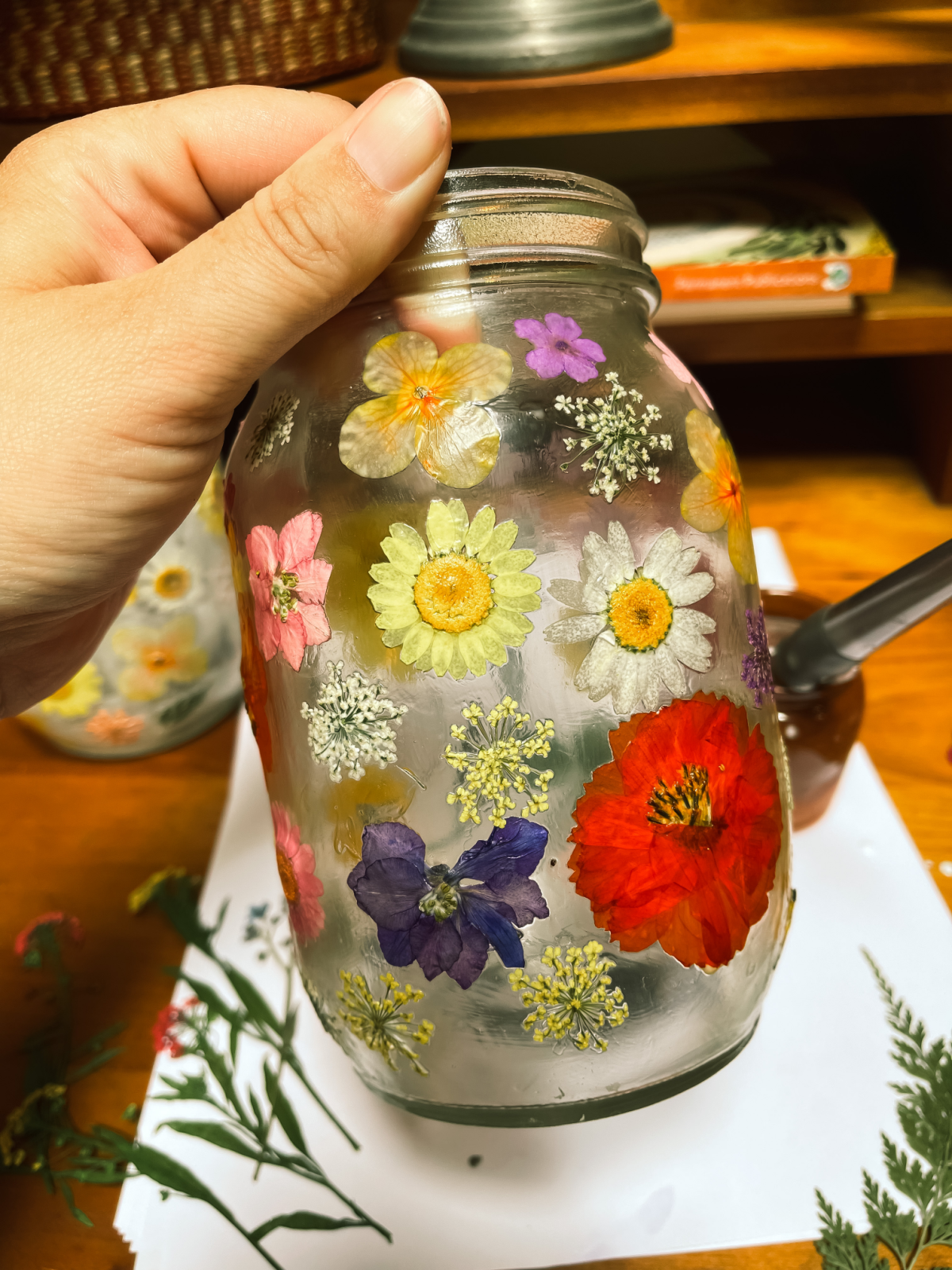 pressing flowers onto a jar 