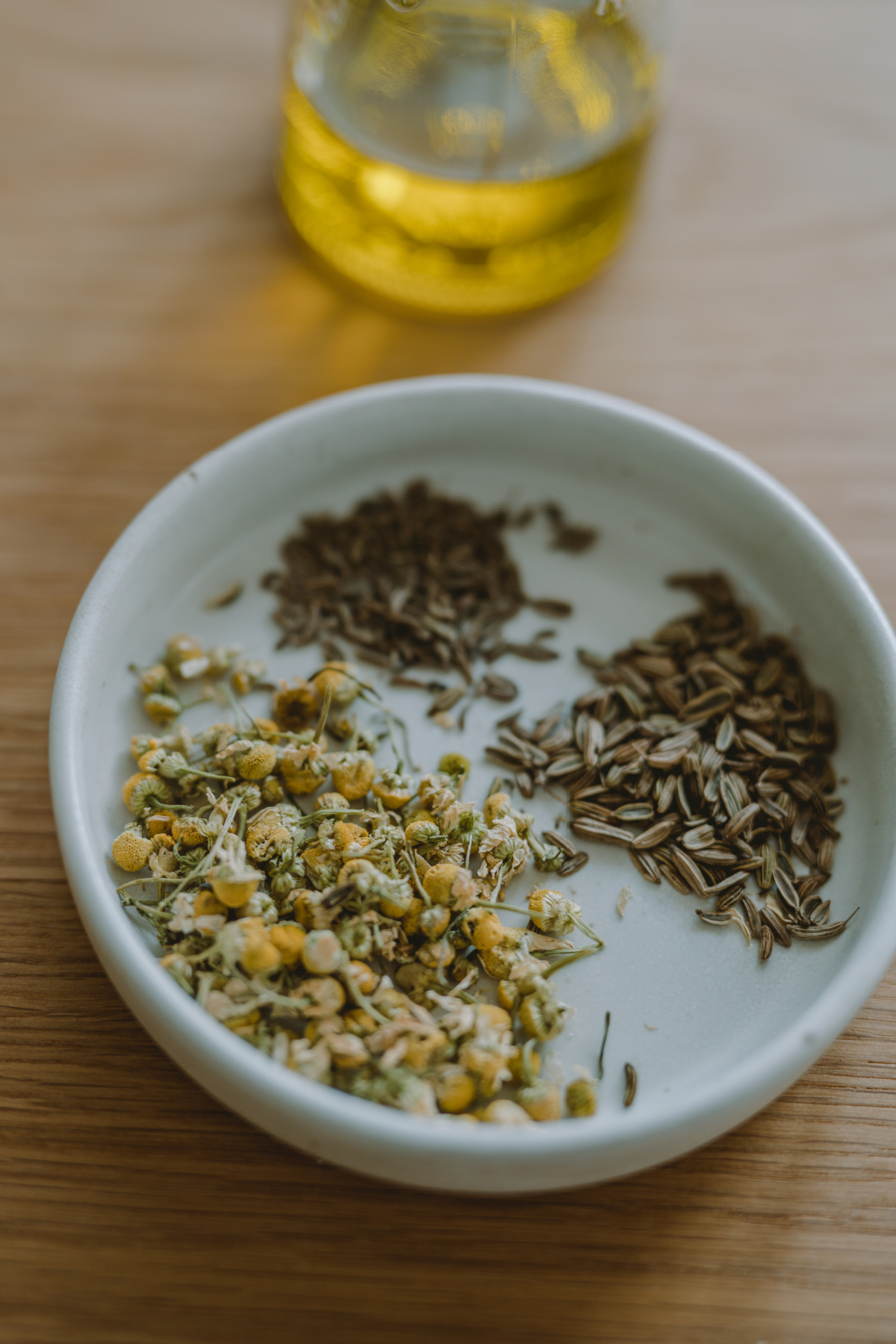 herbs on a plate with crampy belly oil in the background