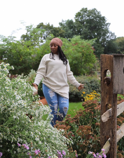 woman walking through patches of herbs