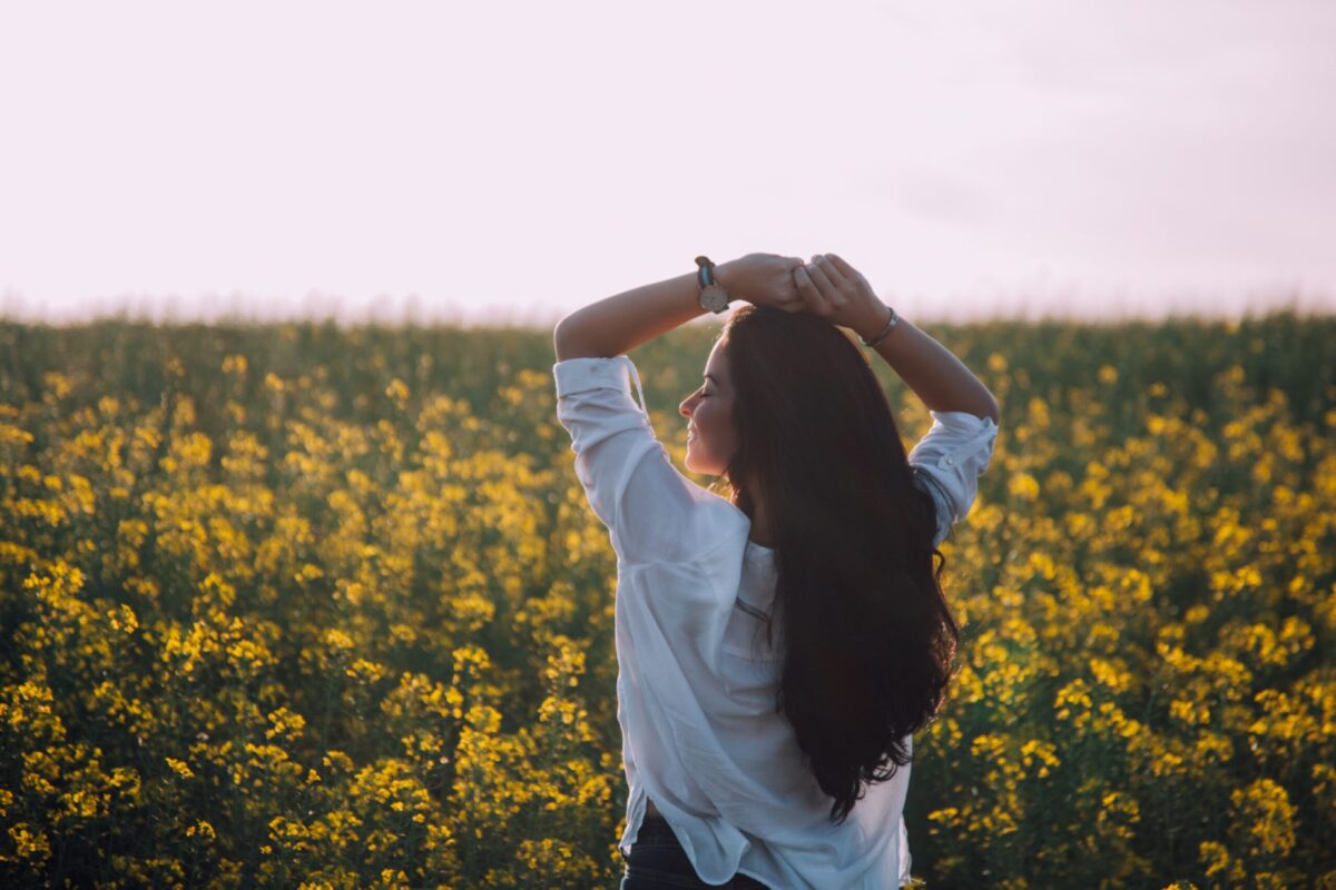 peaceful woman standing next to a field