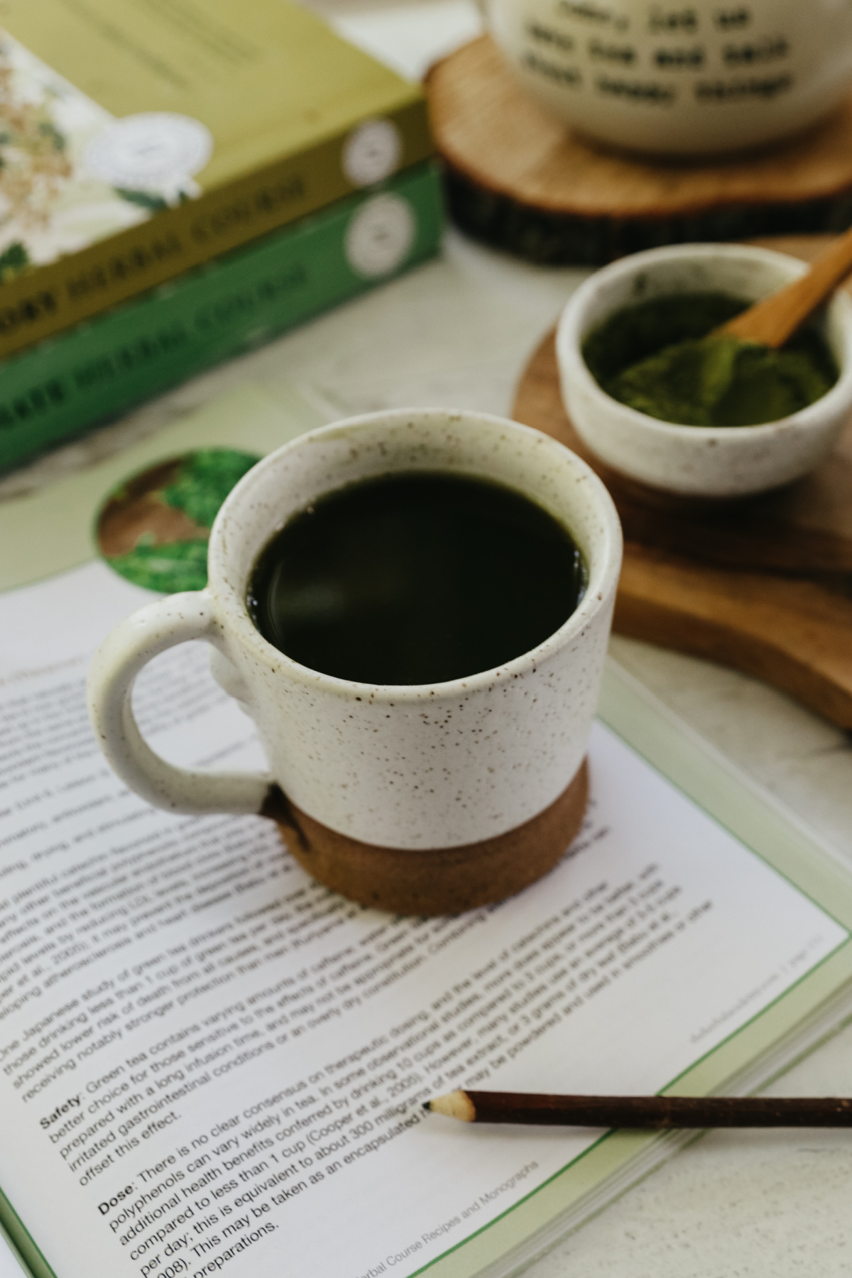 cup of matcha tea sitting on a book