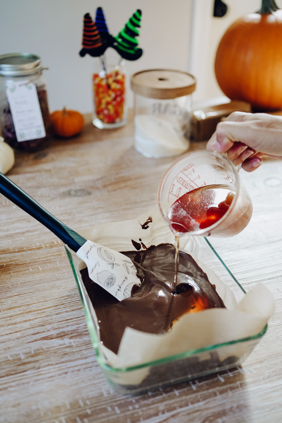 pouring rose syrup into melted chocolate