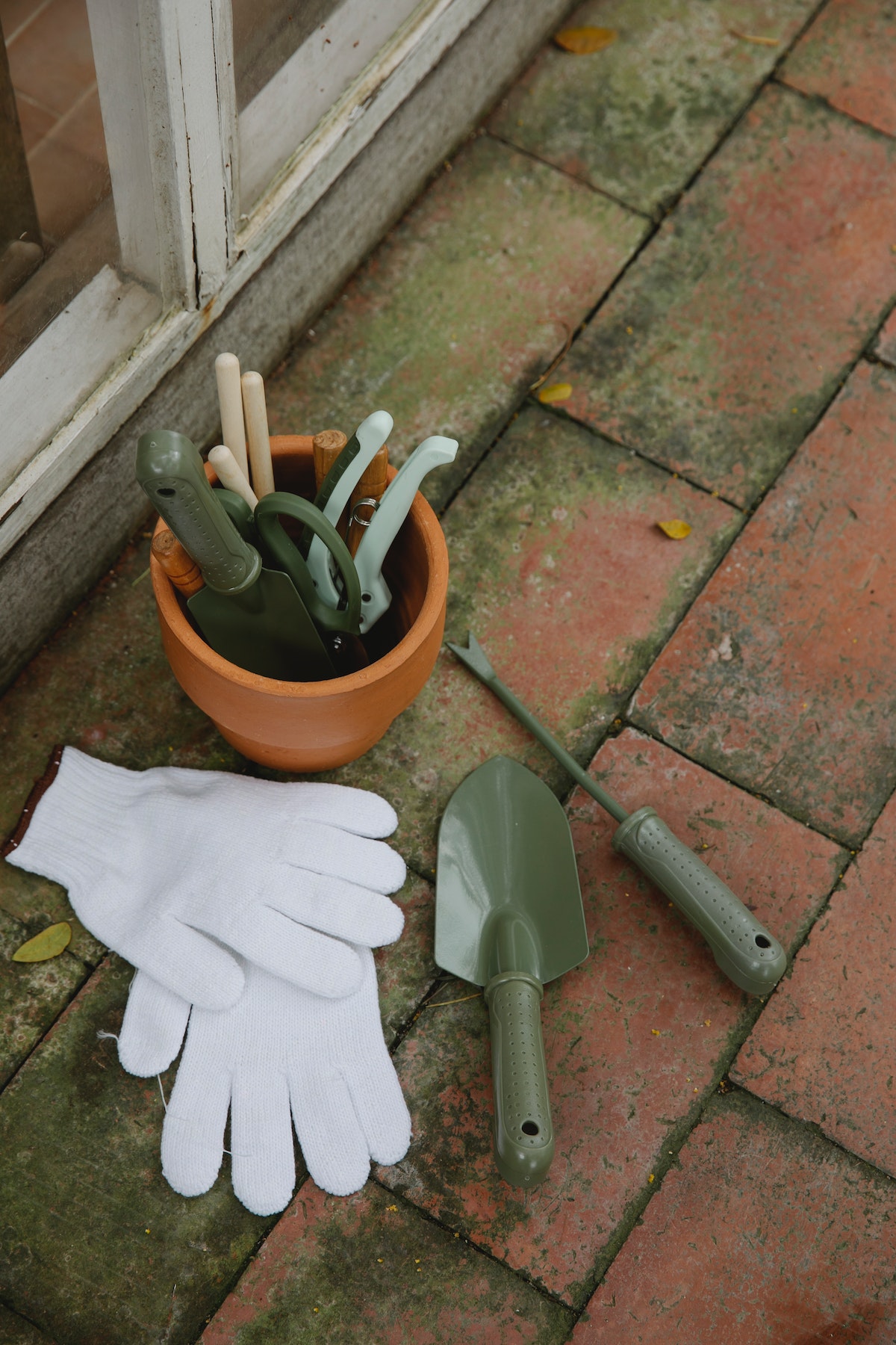 garden tools and gloves on brick floor
