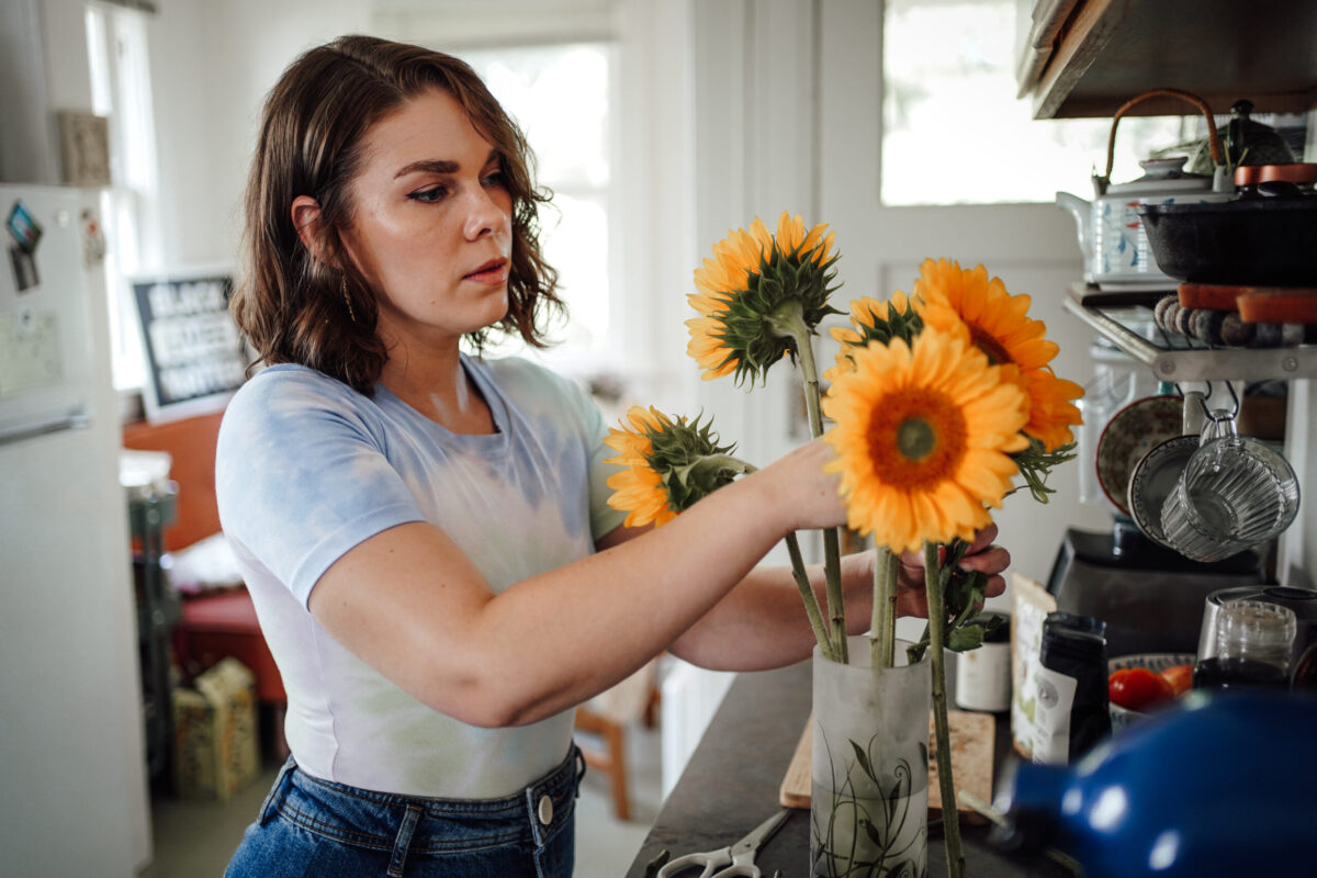 woman arranging sunflowers