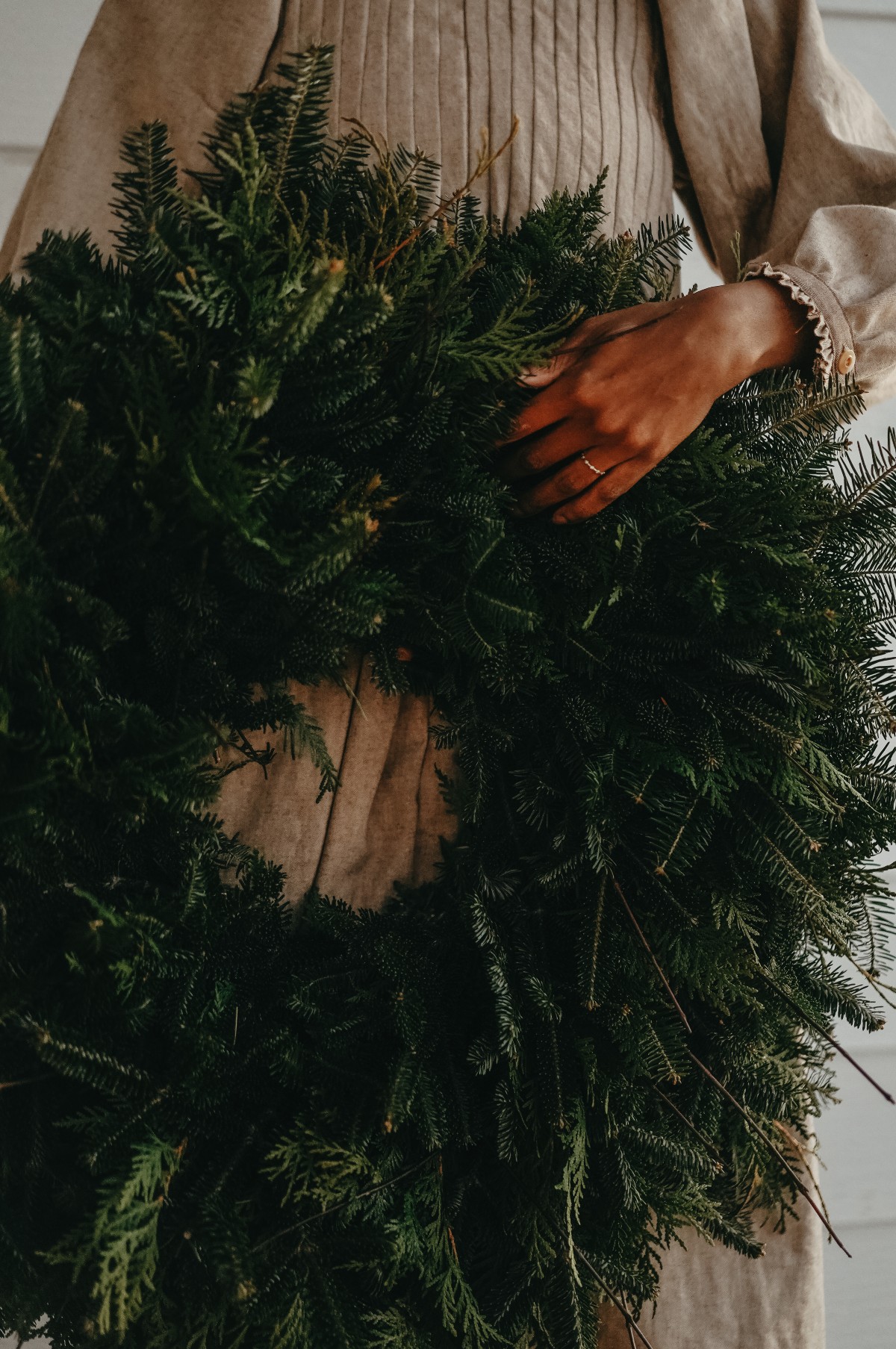 woman holding a large wreath