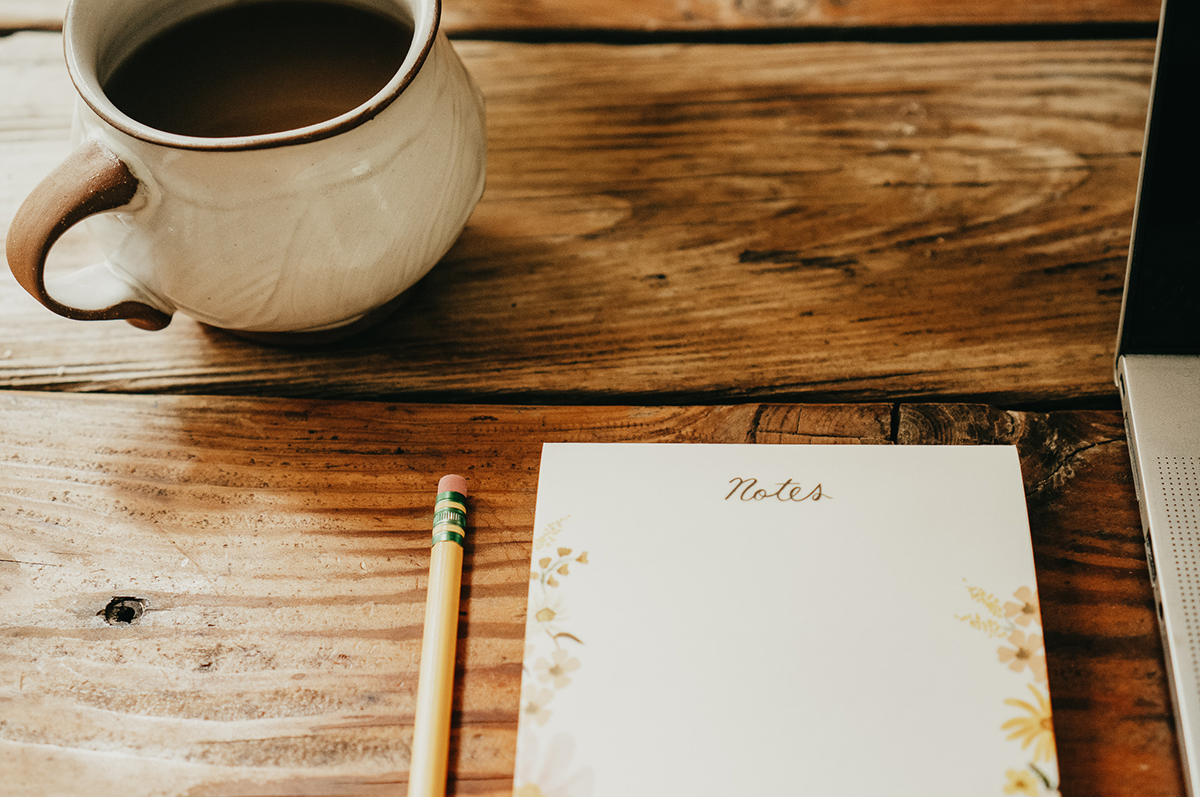 notebook with pencil and cup of coffee