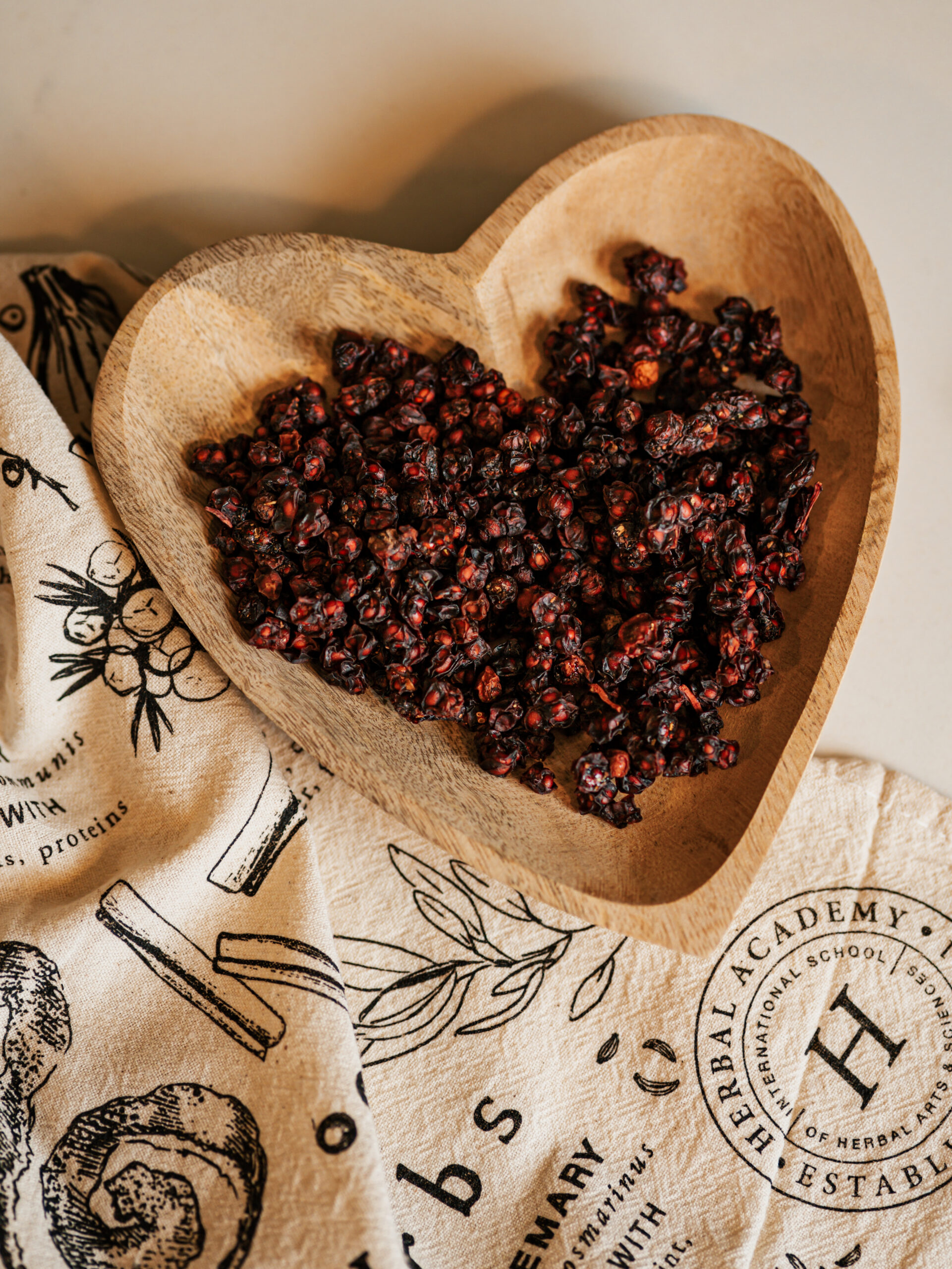 schisandra berries in a heart bowl sitting on Herbal Academy towel