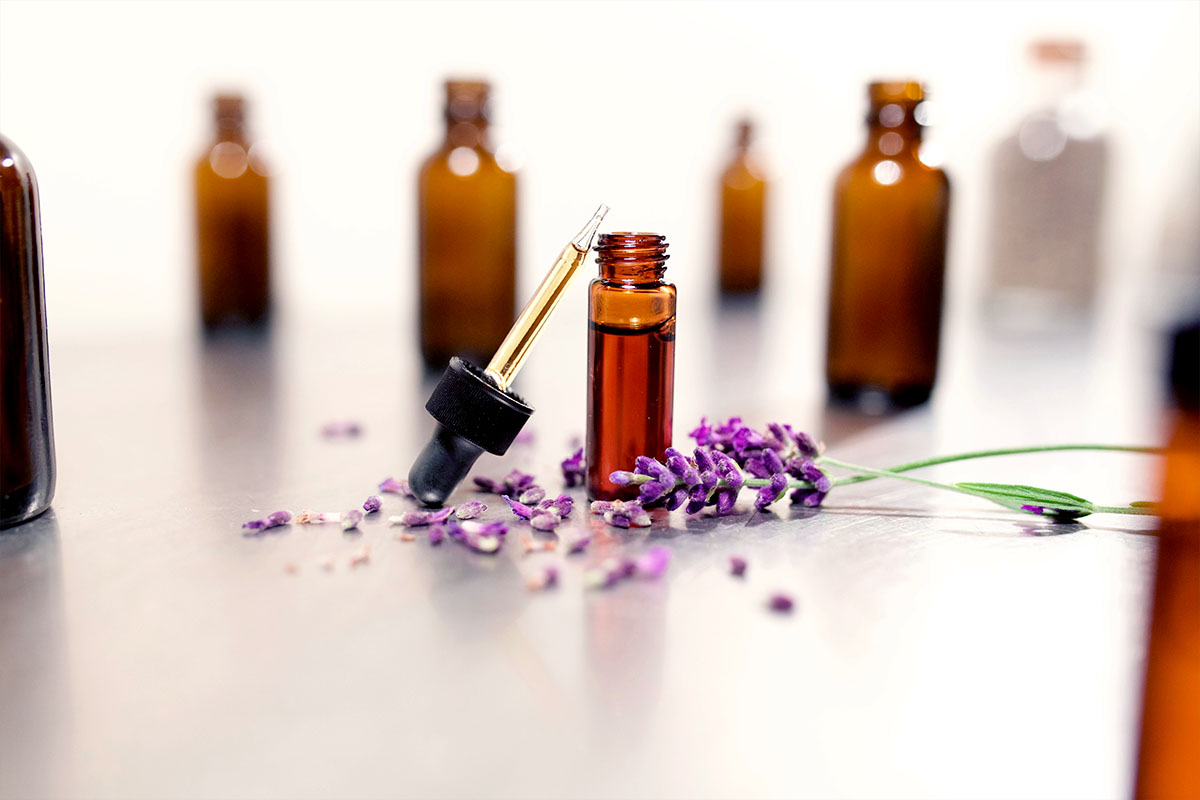 bottles of lavender essential oil with lavender flowers on the table