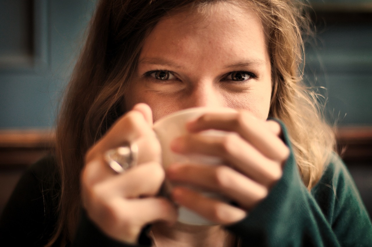 woman looking at camera while drinking tea