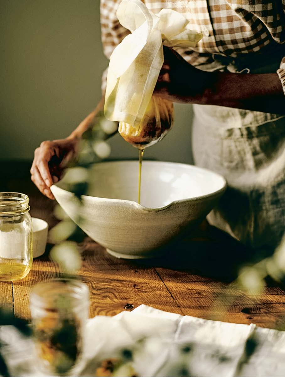 woman straining an oxymel into a bowl