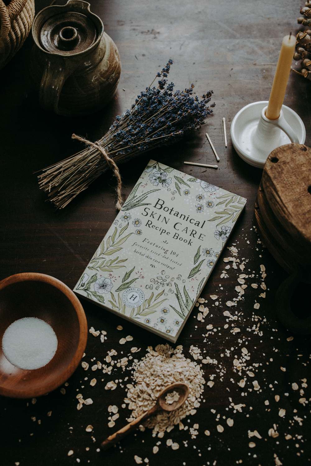  Botanical Skin Care Recipe Book and herbs on a table