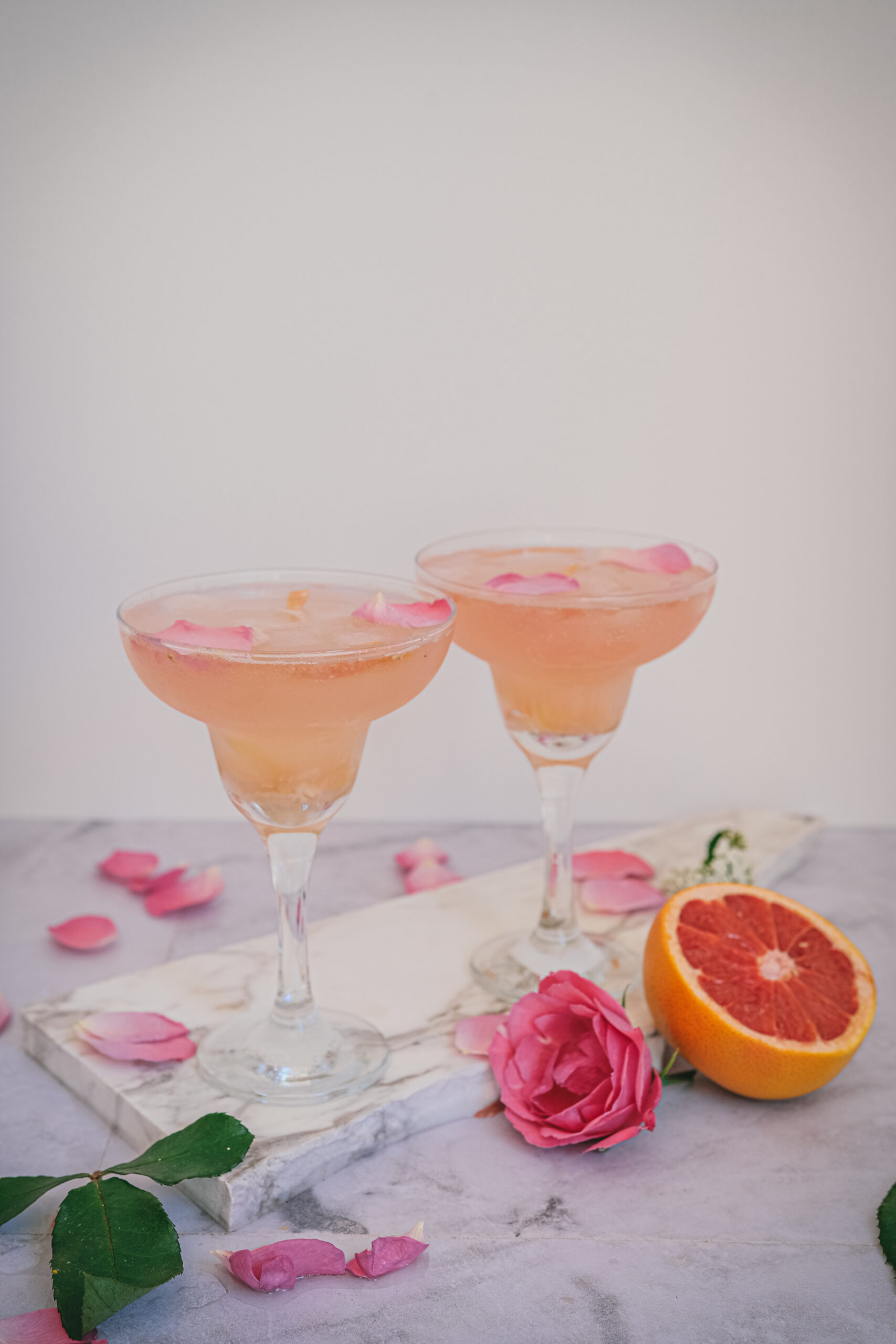 glasses of mocktail with rose and grapefruit on the table