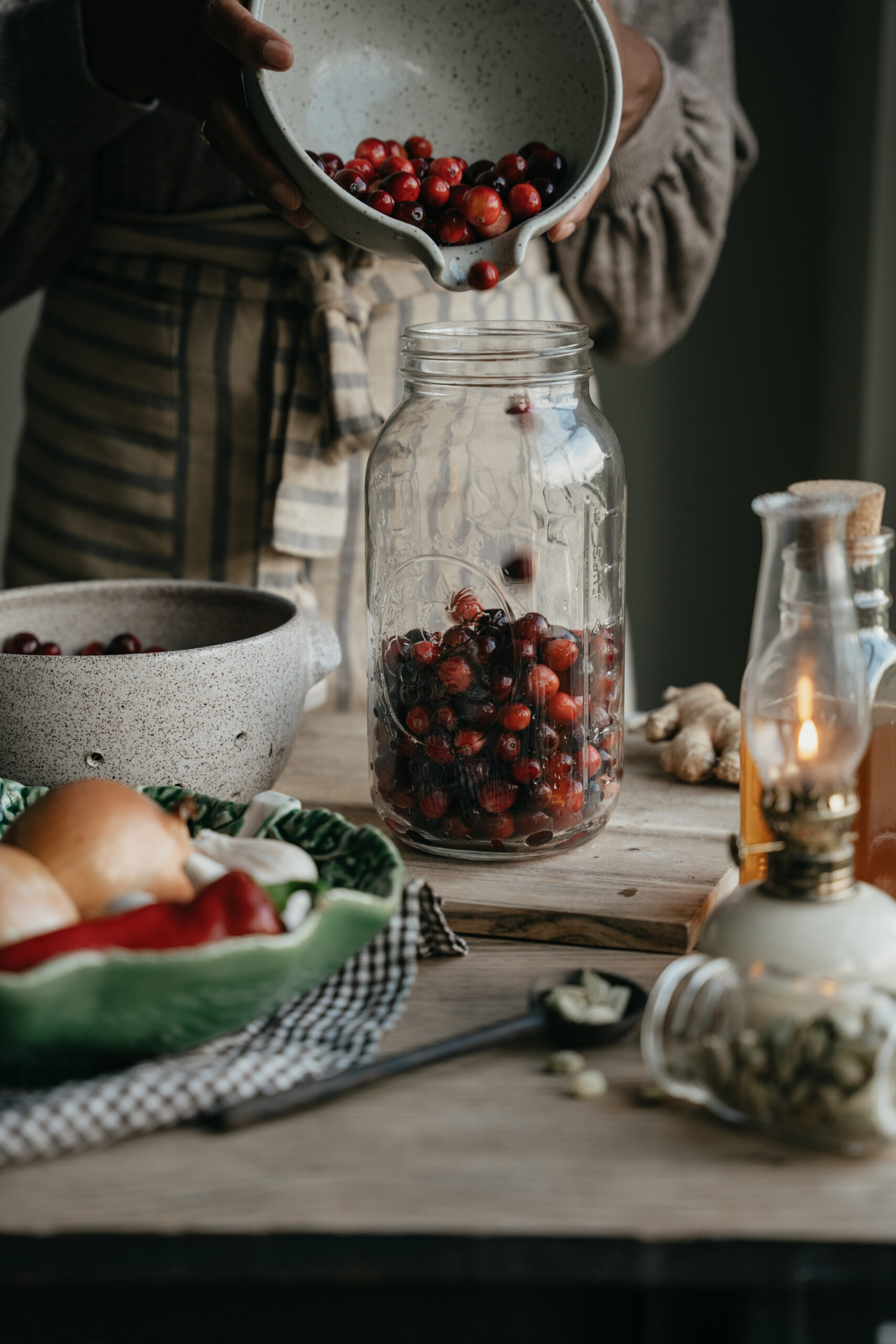 herbalist pouring cranberries into a jar