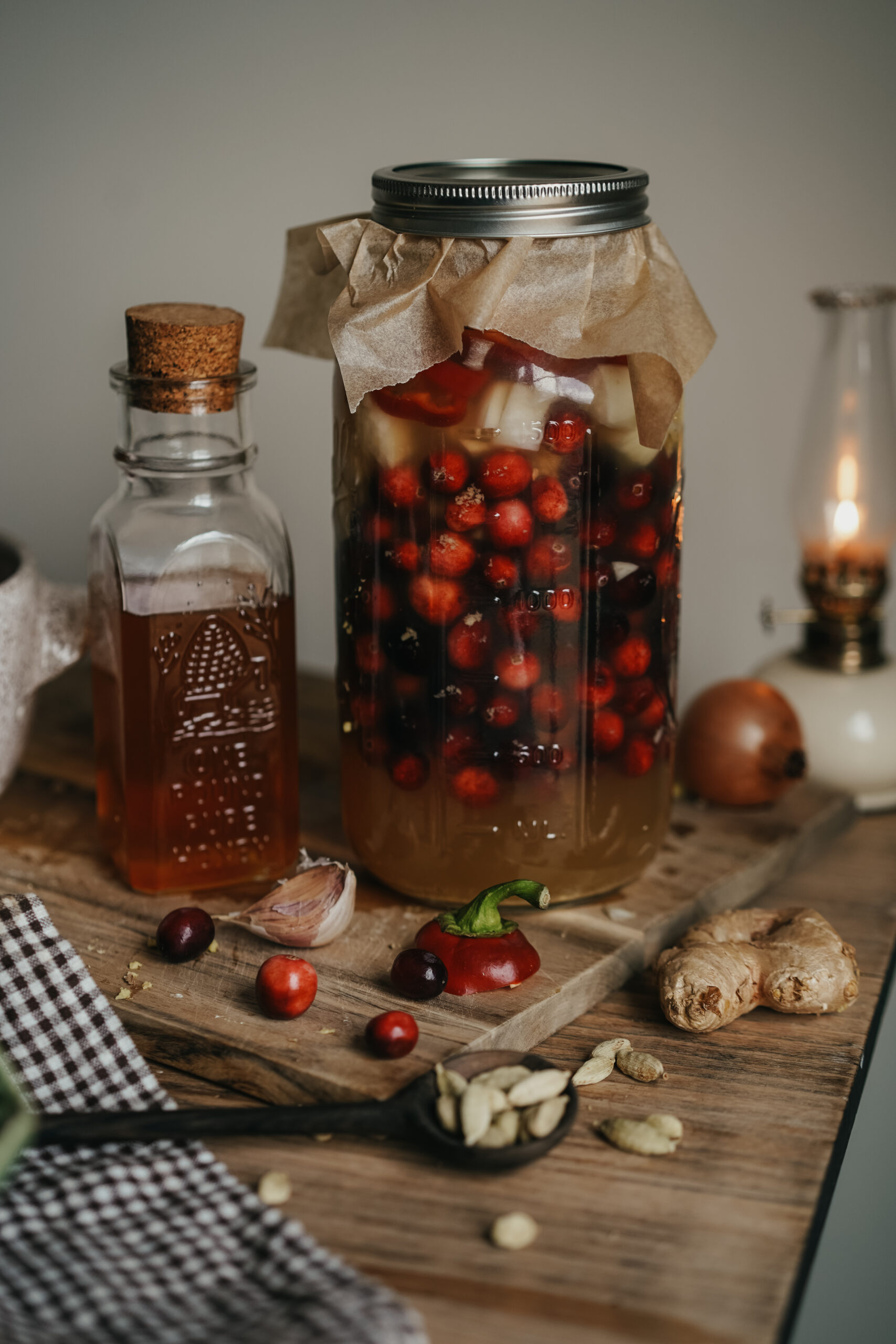 jar of fire cider on a wooden cutting board next to a bottle of honey