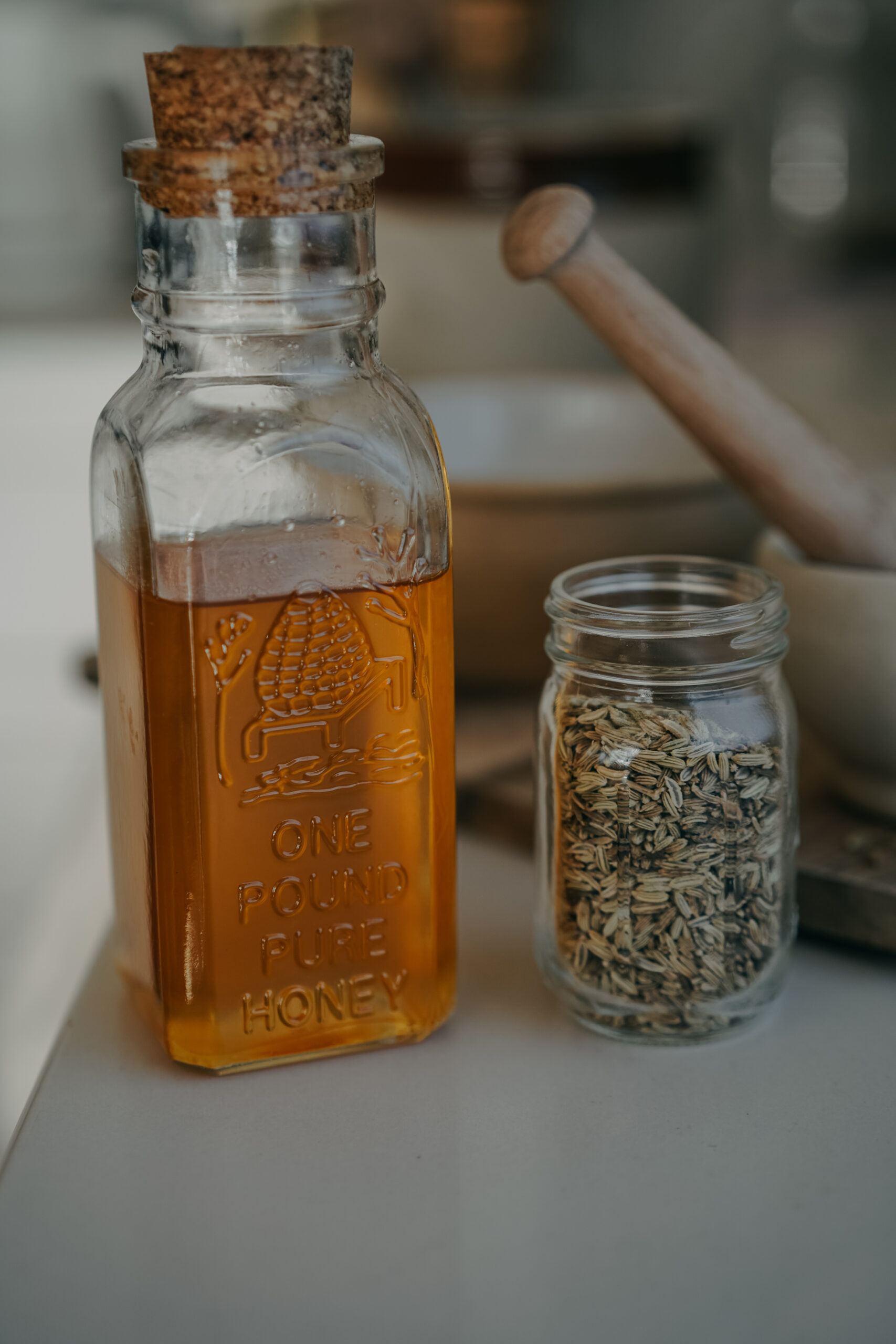 jar of honey next to a jar of herbs