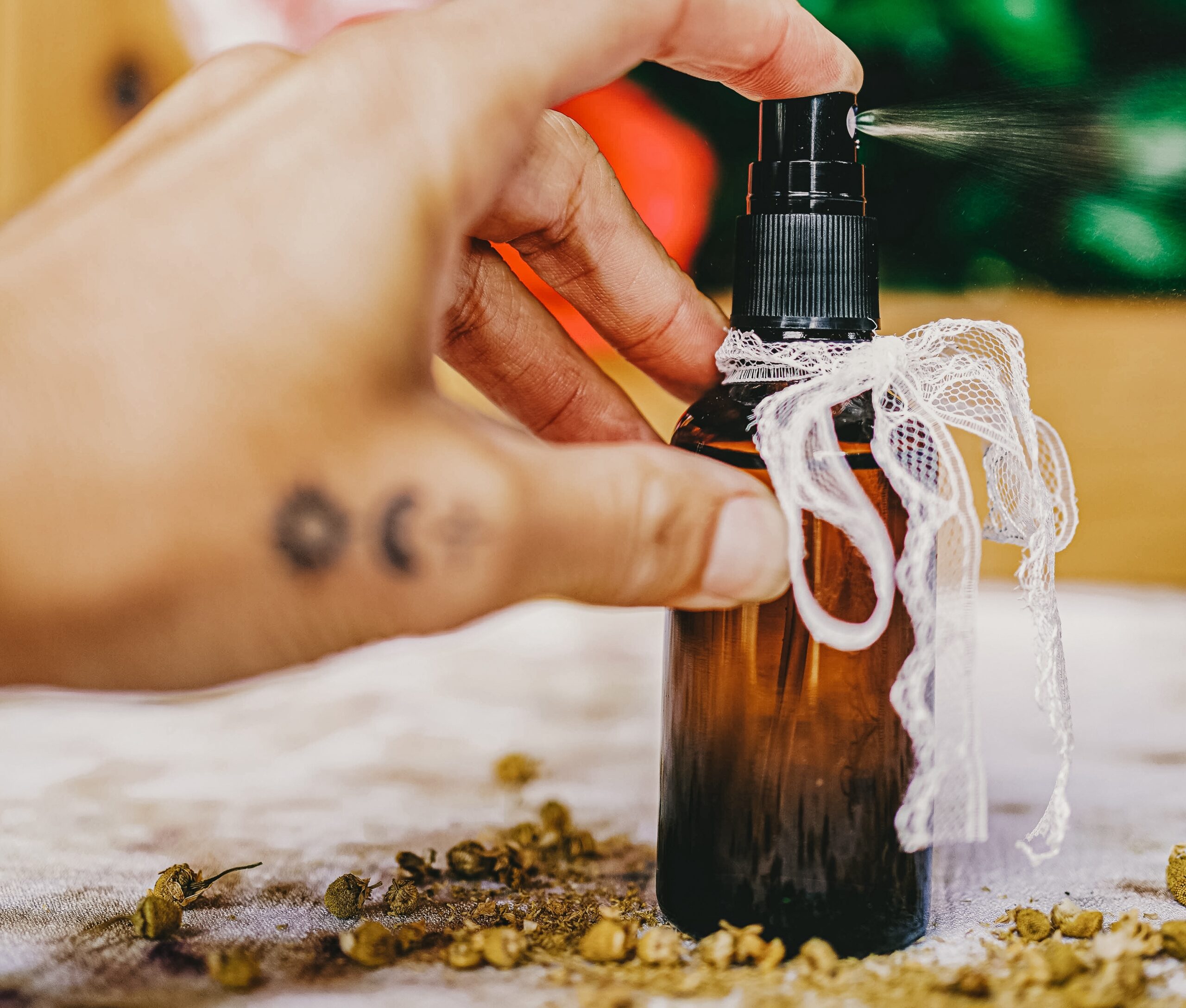 hand spraying a dark colored spray bottle