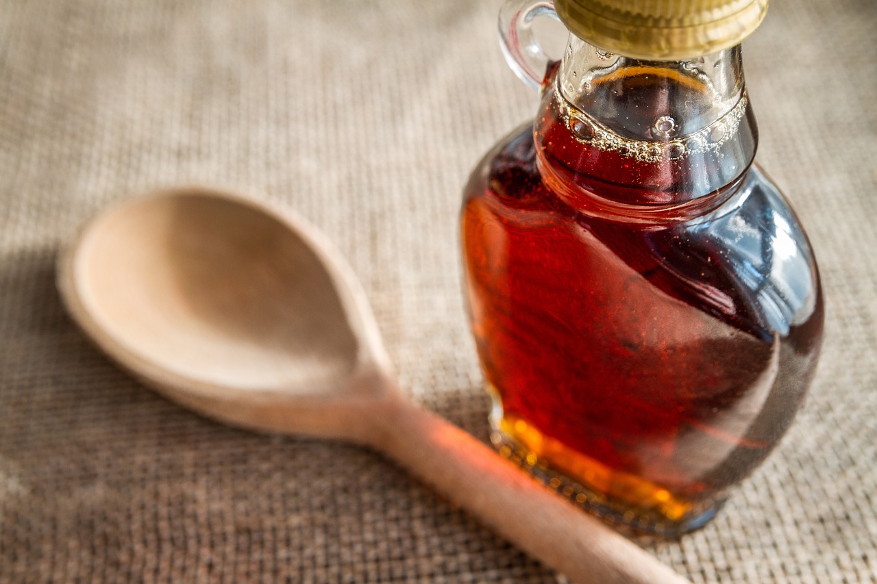 jar of maple syrup with a wooden spoon
