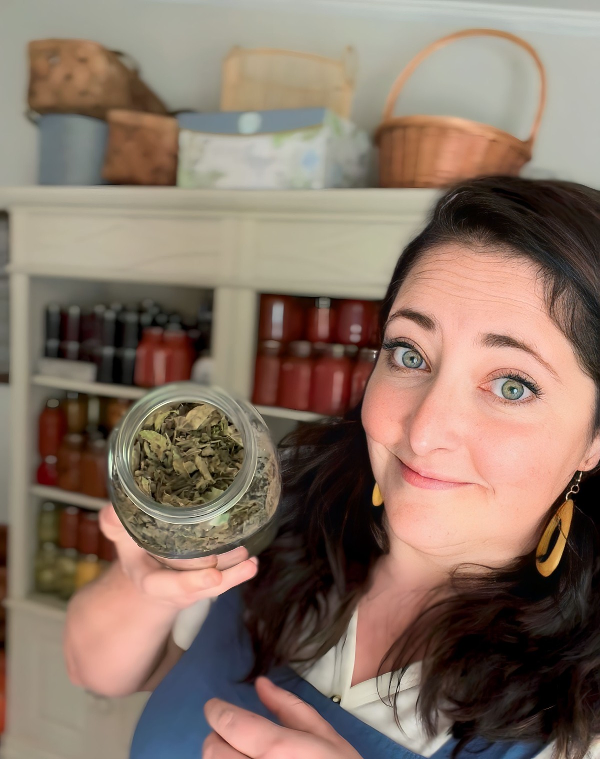Amber Benge showing a jar of dried herbs
