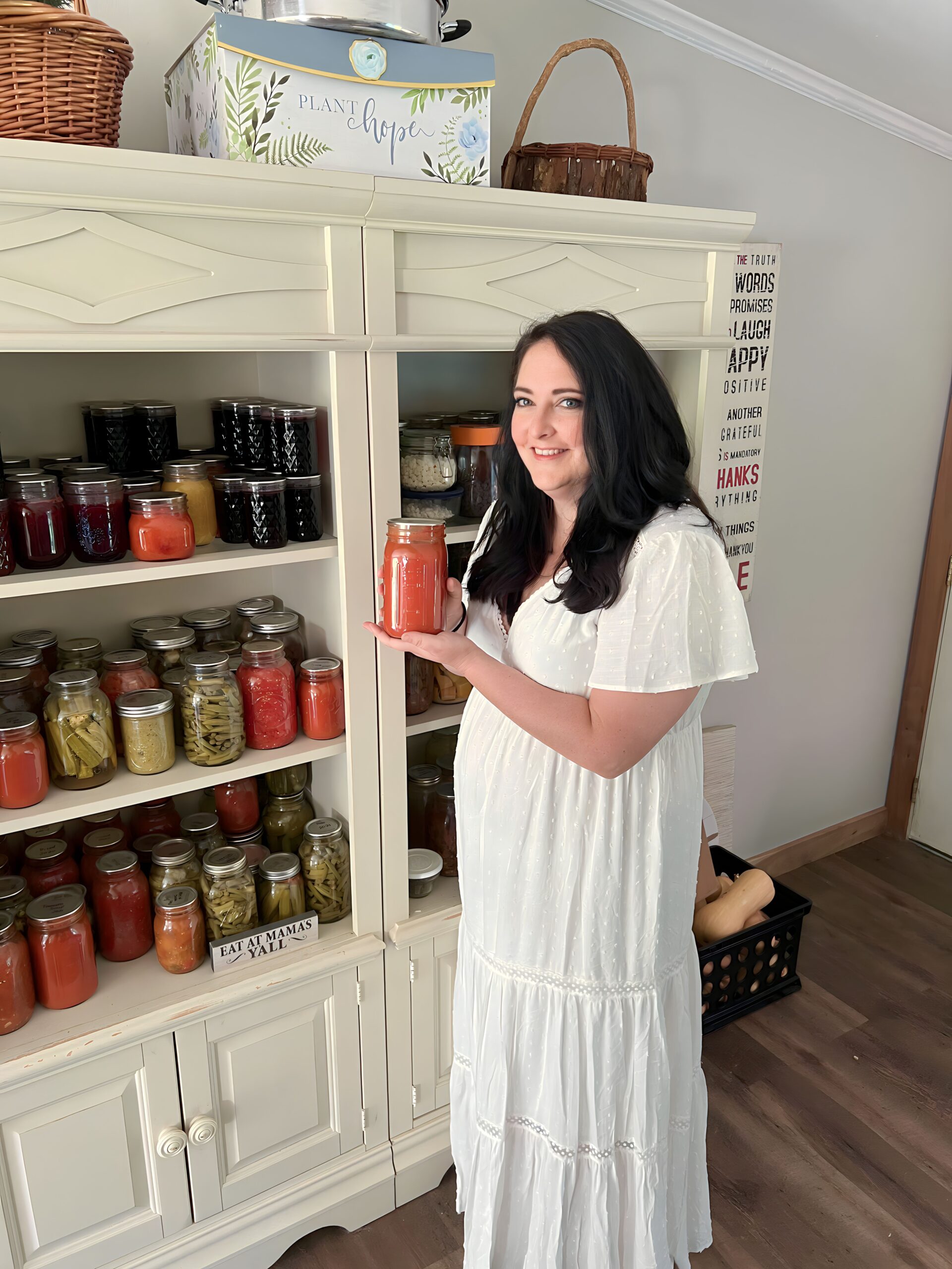 woman showing a home canned jar of tomatoes