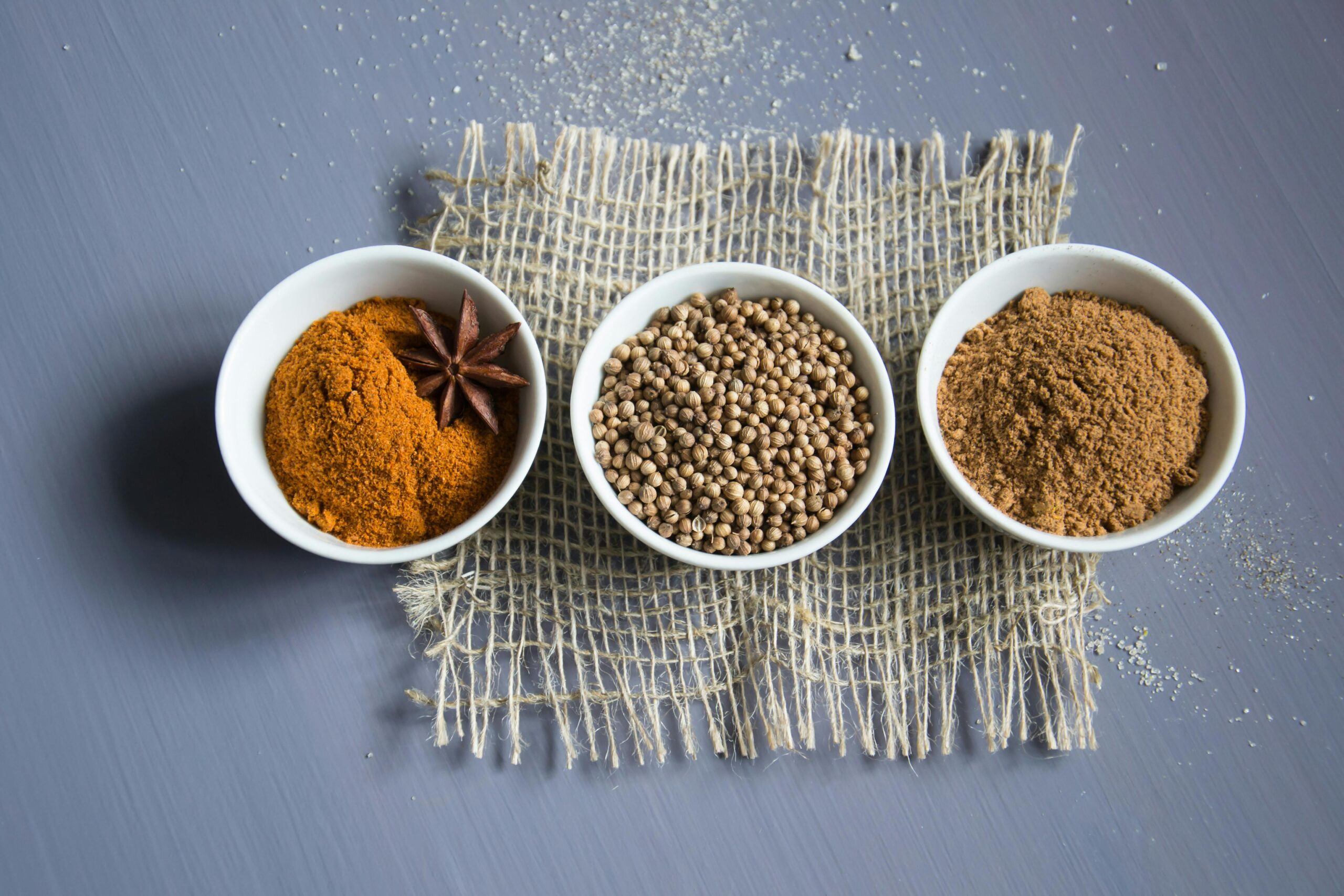 spices in three white bowls