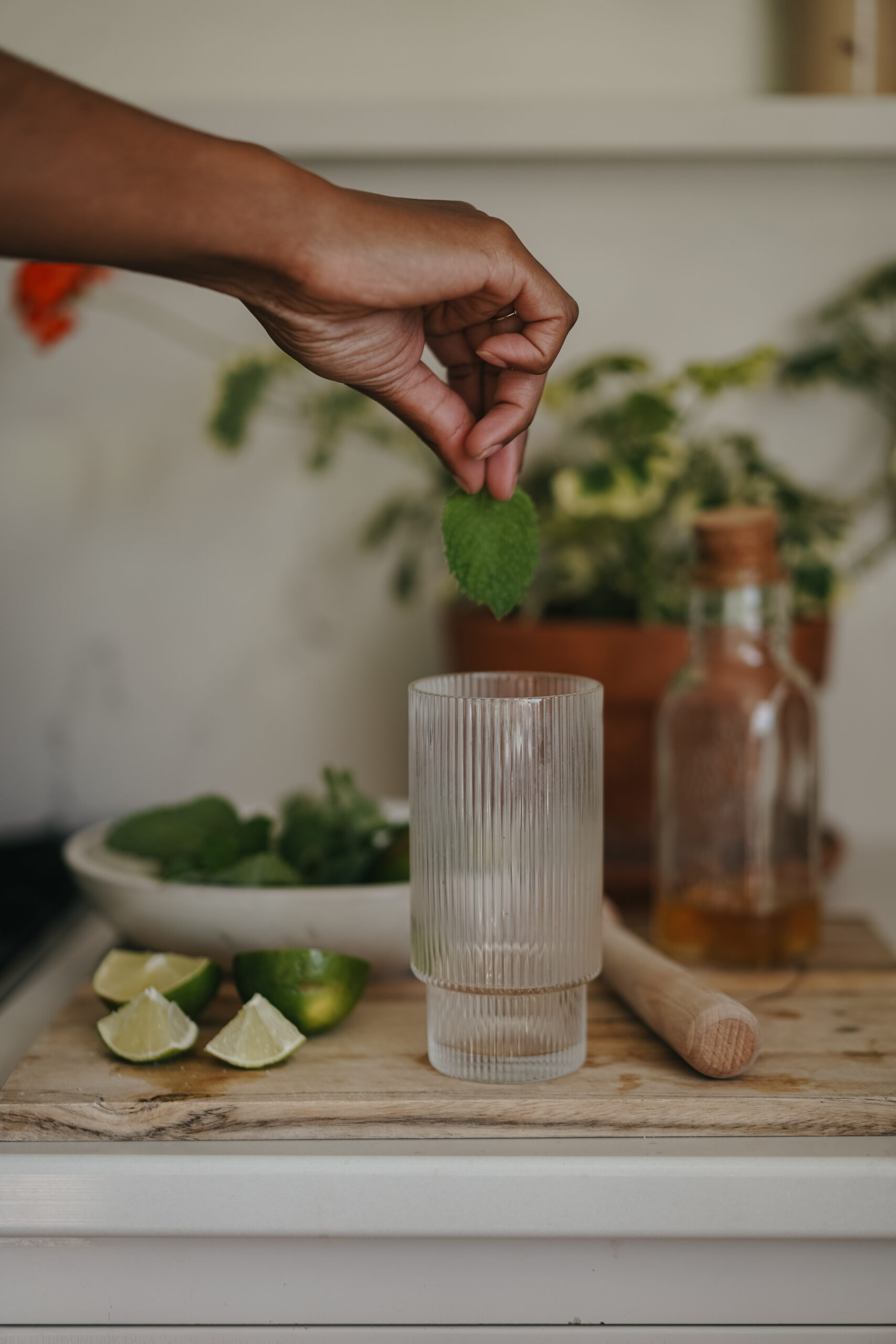 placing a mint leaf in a glass