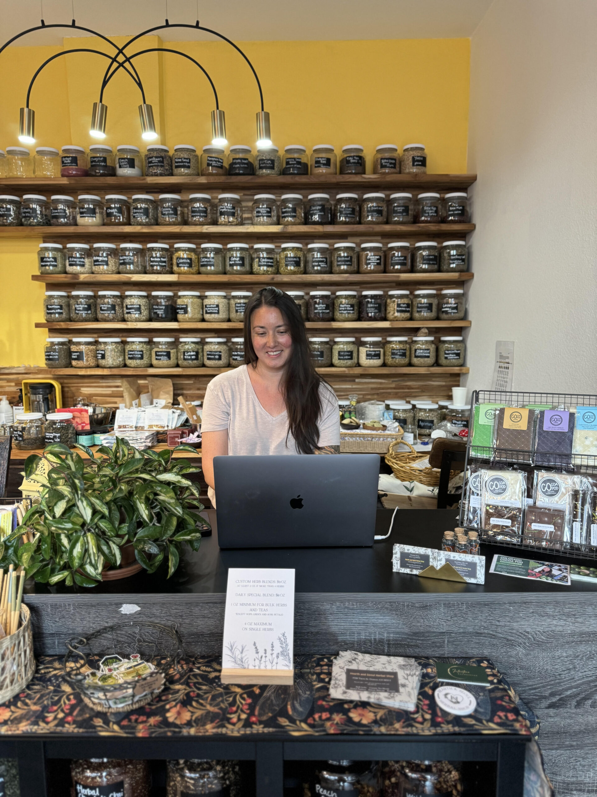 Christine in her herb shop looking at a laptop