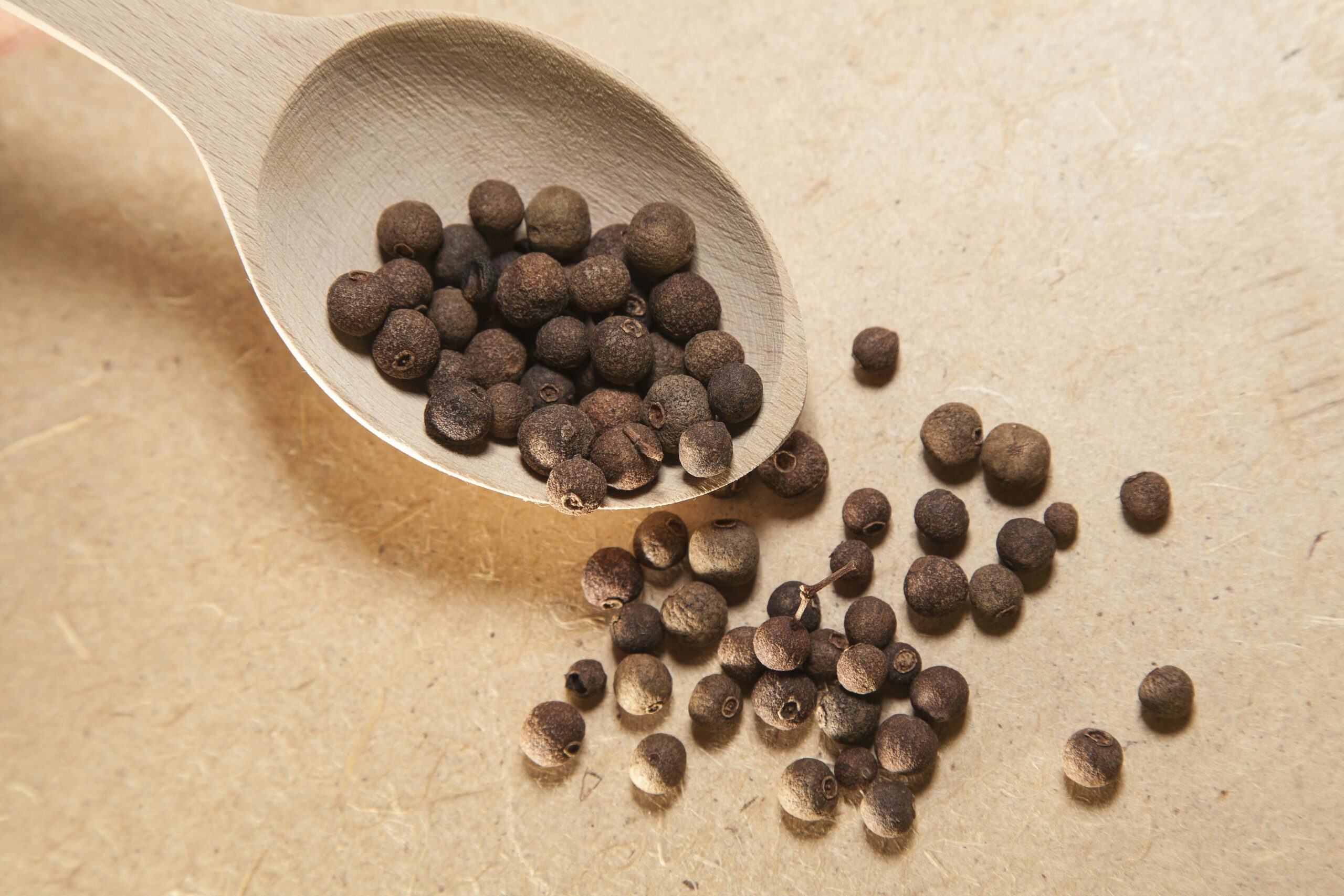 allspice spilling off a wooden spoon