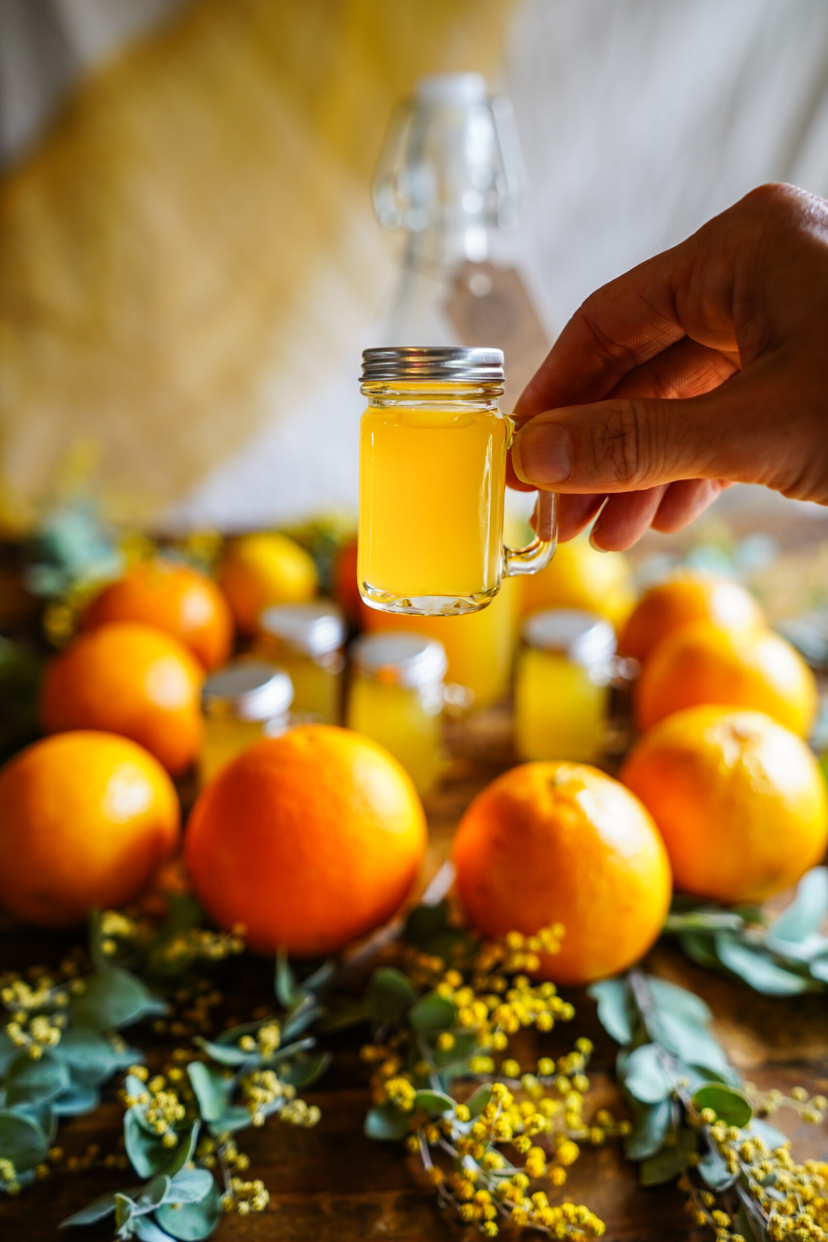 hand holding up a mini jar of herbal immunity shots