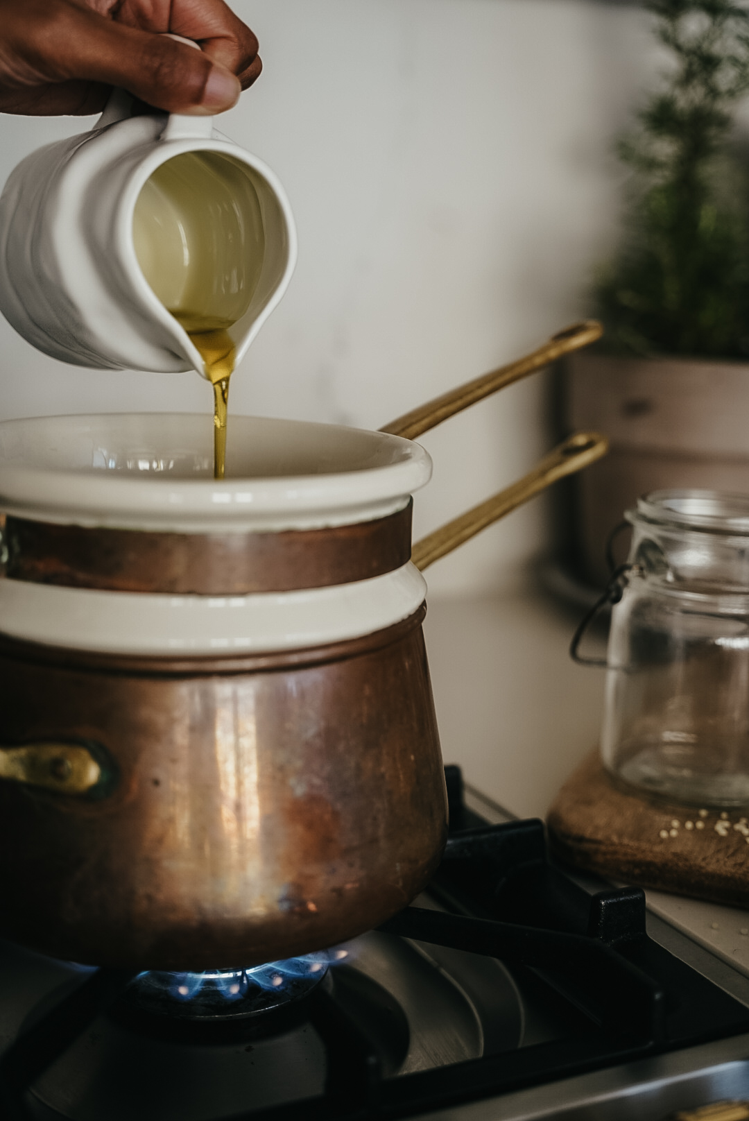 pouring oil into a pot on the stove