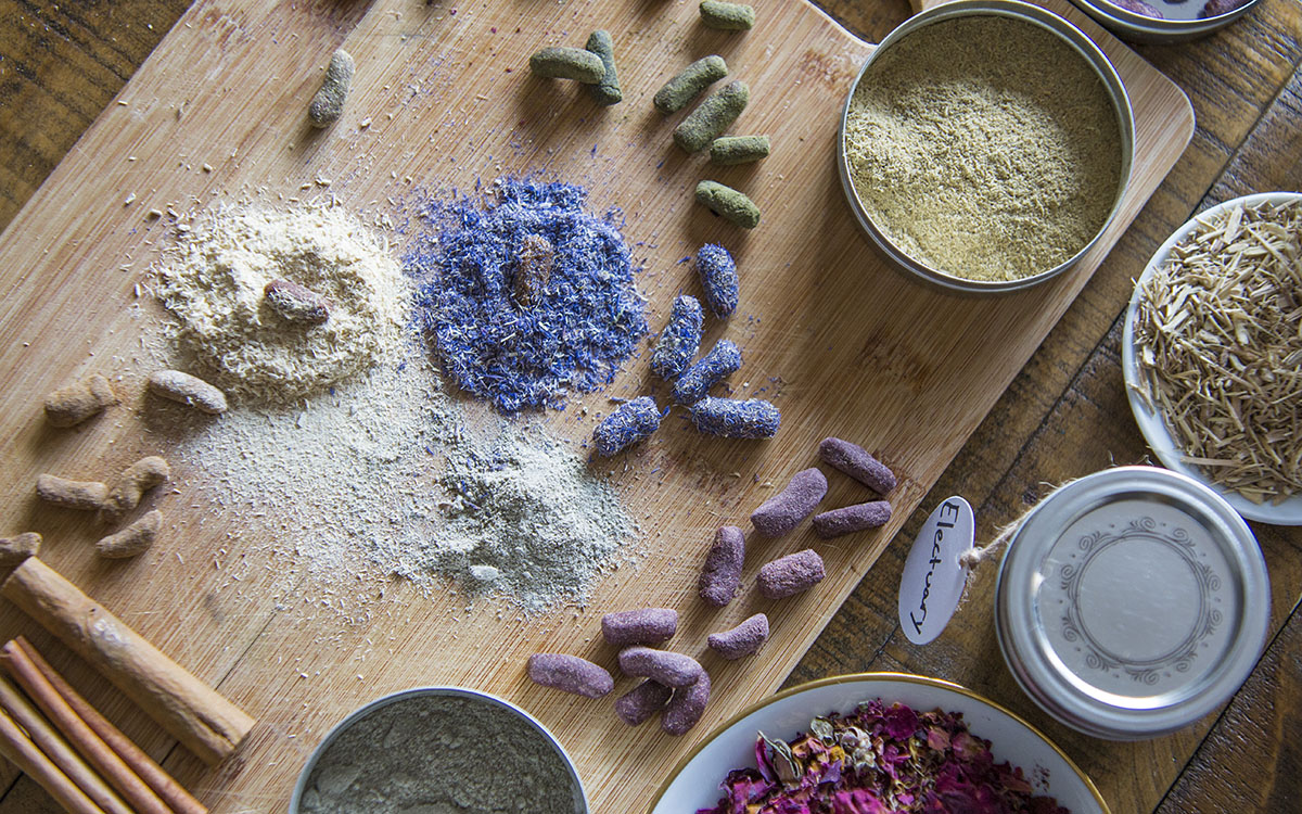 herbal pastilles with bowls of herbs surrounding 