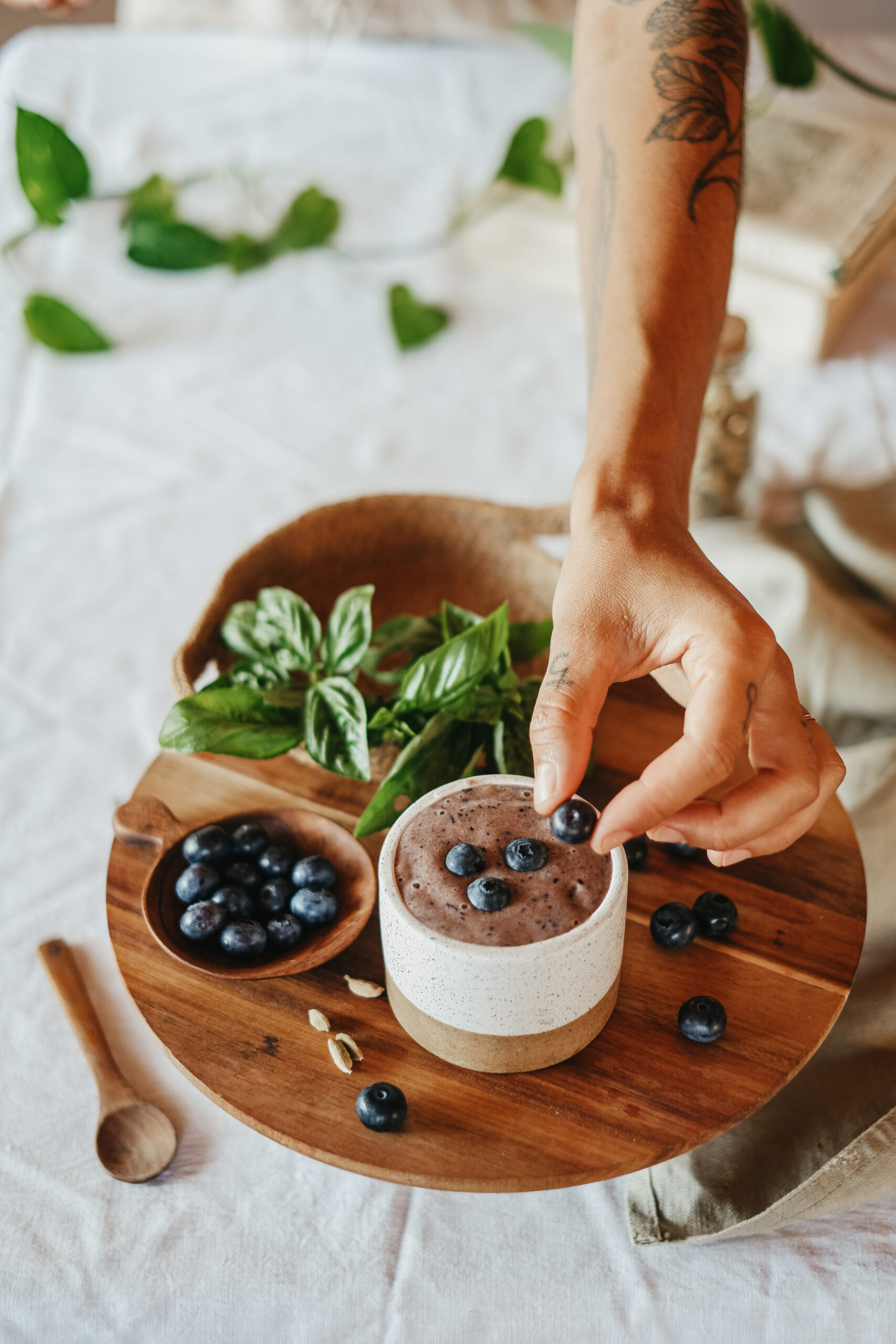 hand placing a blueberry on top of blueberry basil nice cream
