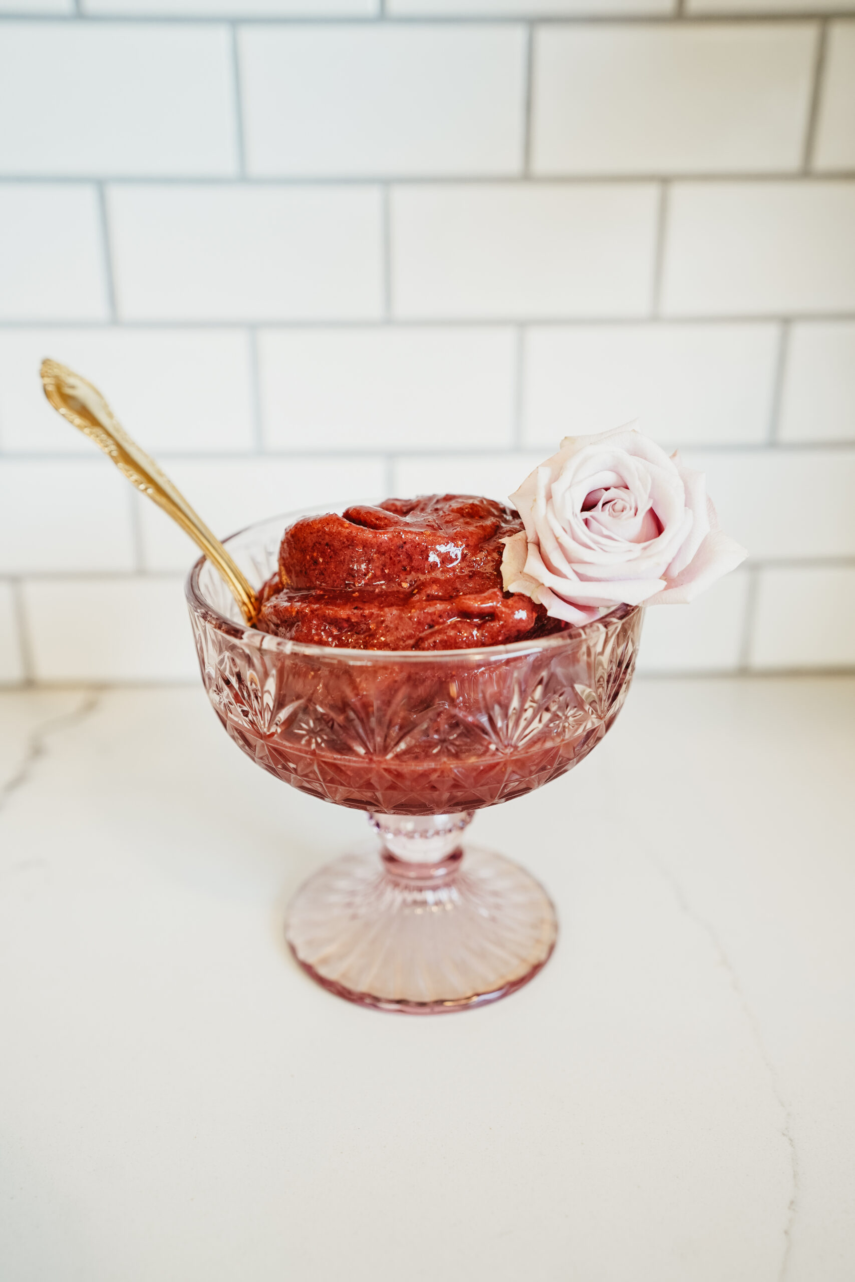 goblet of cherry vanilla nice cream with a rose and spoon