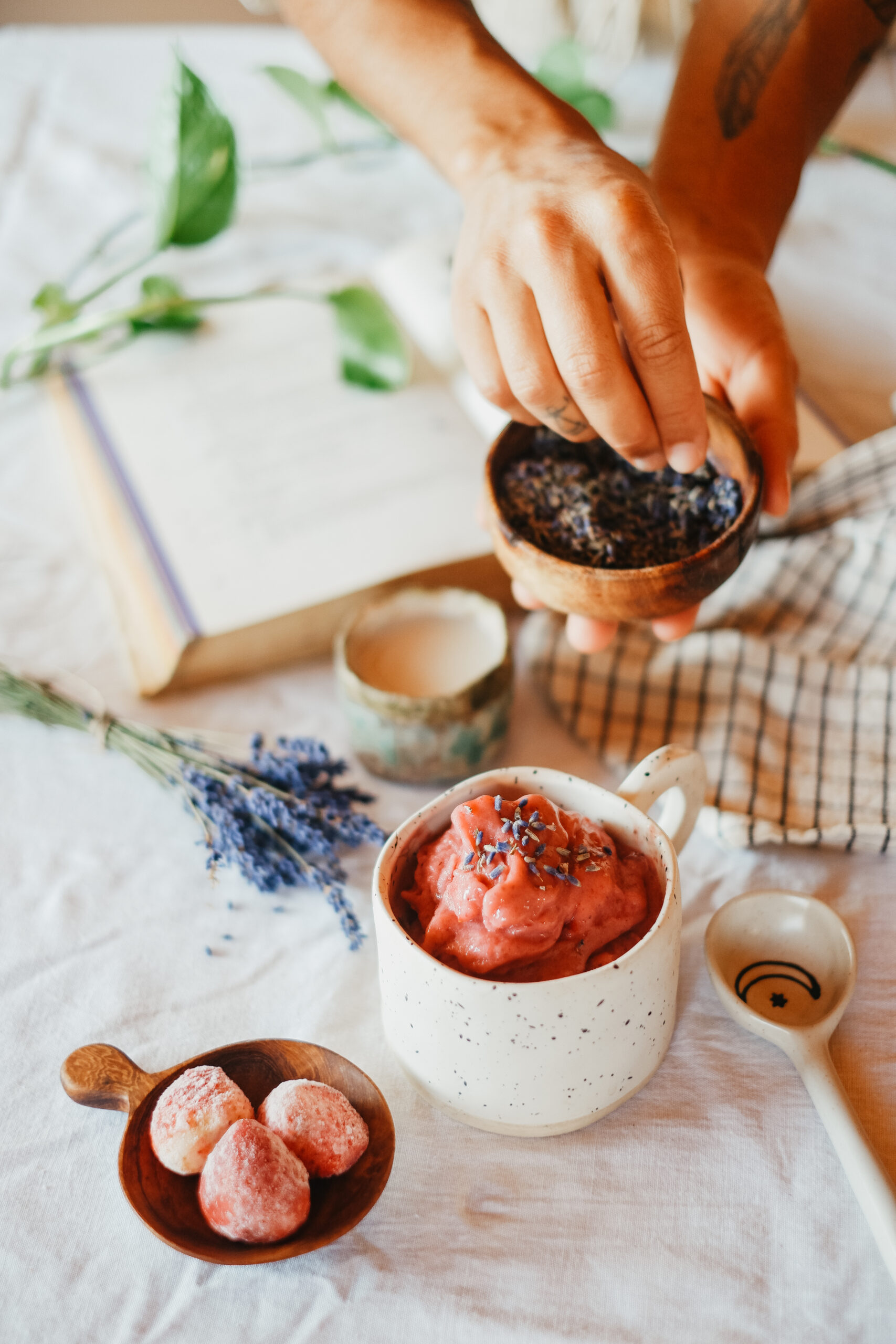 herbalist placing lavender buds on a mug of nice cream