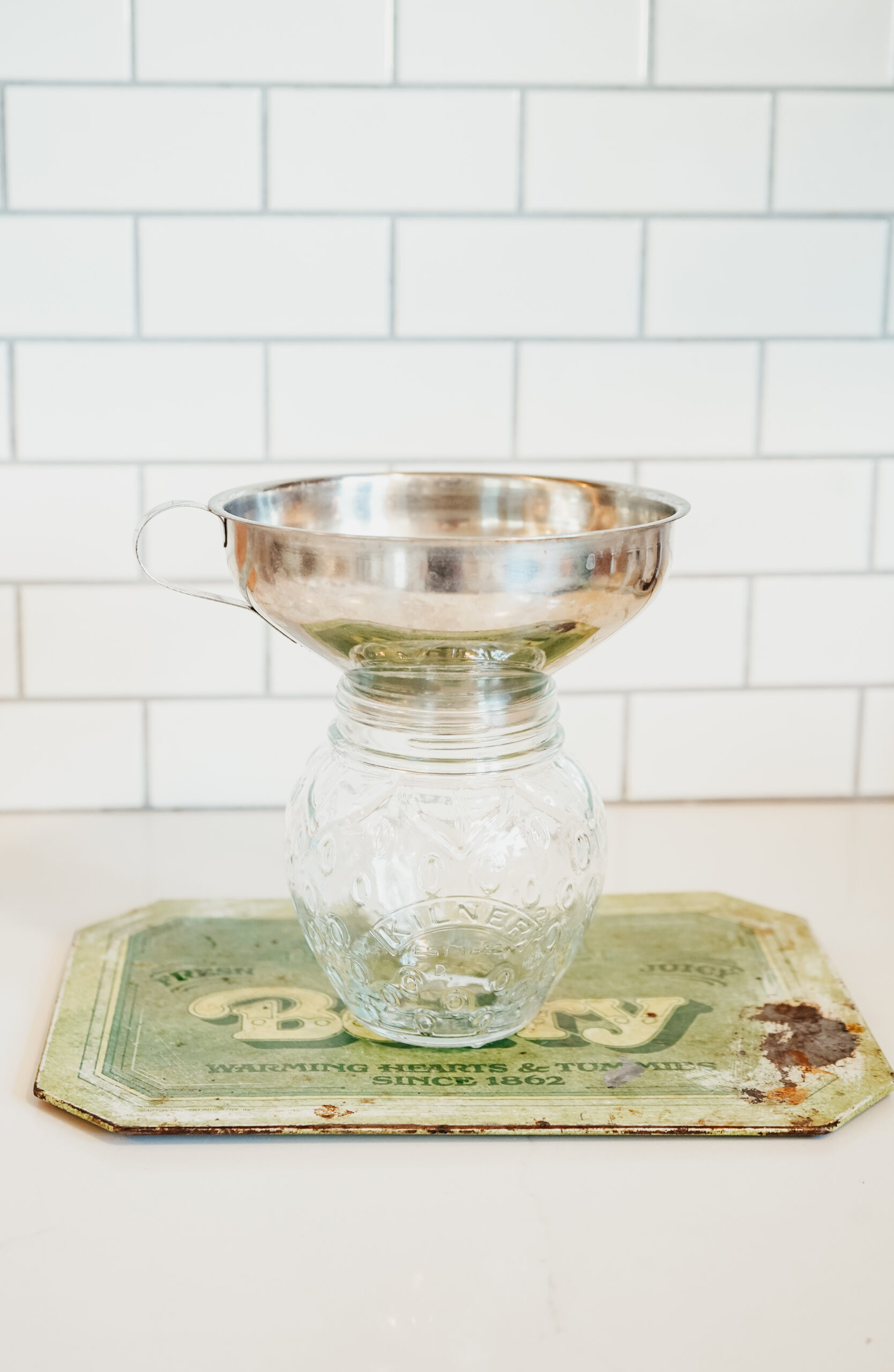 Discover this shimmering jam that perfectly captures the subtle beauty of the changing seasons: a Rosey Rose Hip Jam recipe. jar and strainer sitting on a placemat
