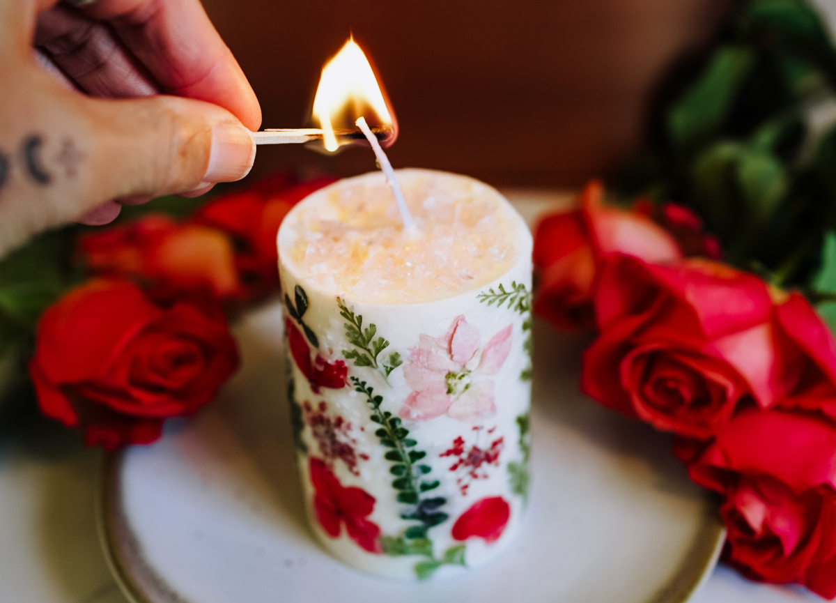 hand lighting an aromatherapy candle