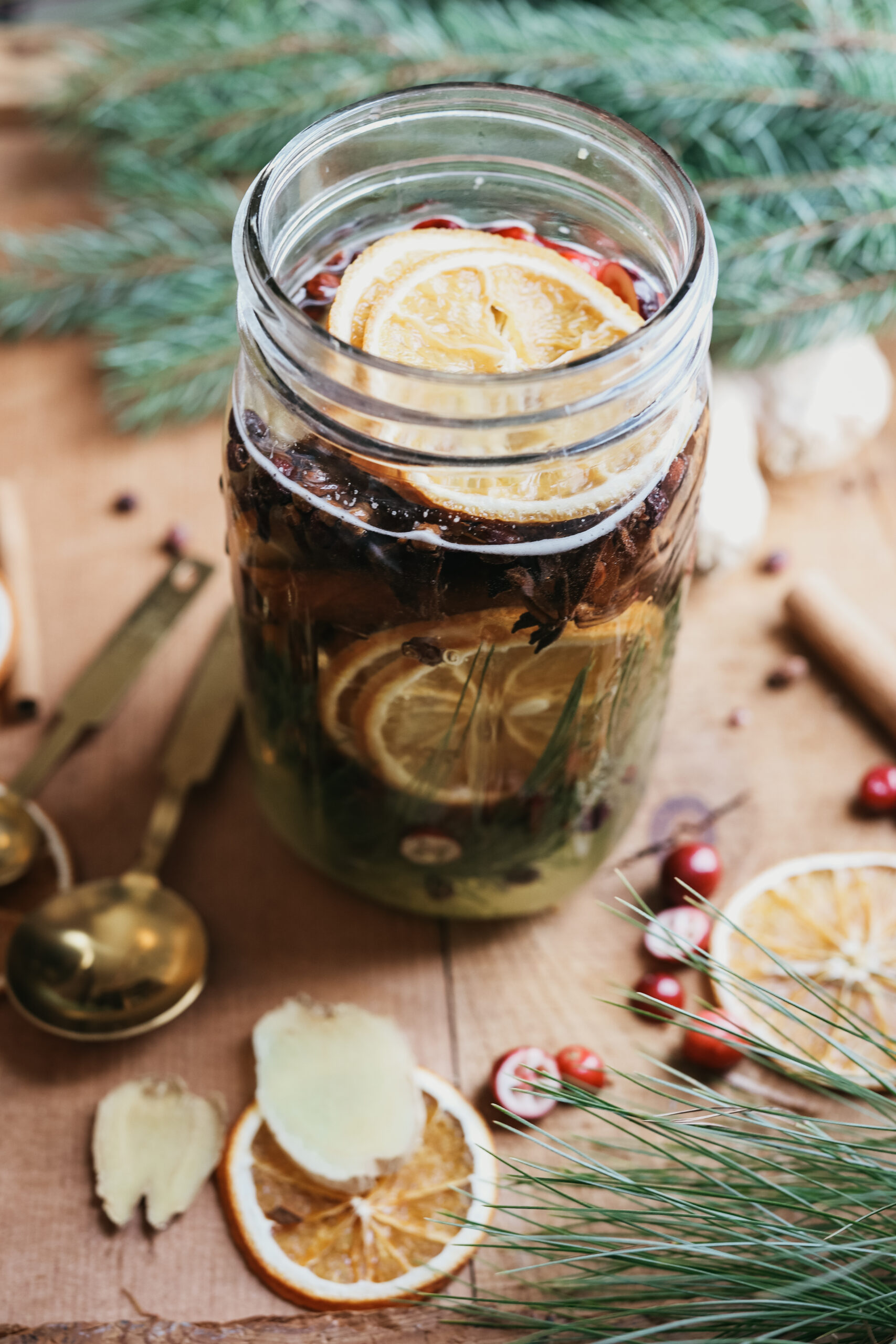 finished jar of herbs with herbs on the table around it