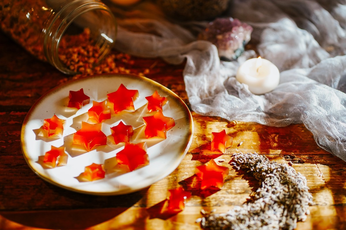 sweet sleep gummies on a plate with herbs and a candle on table next to it