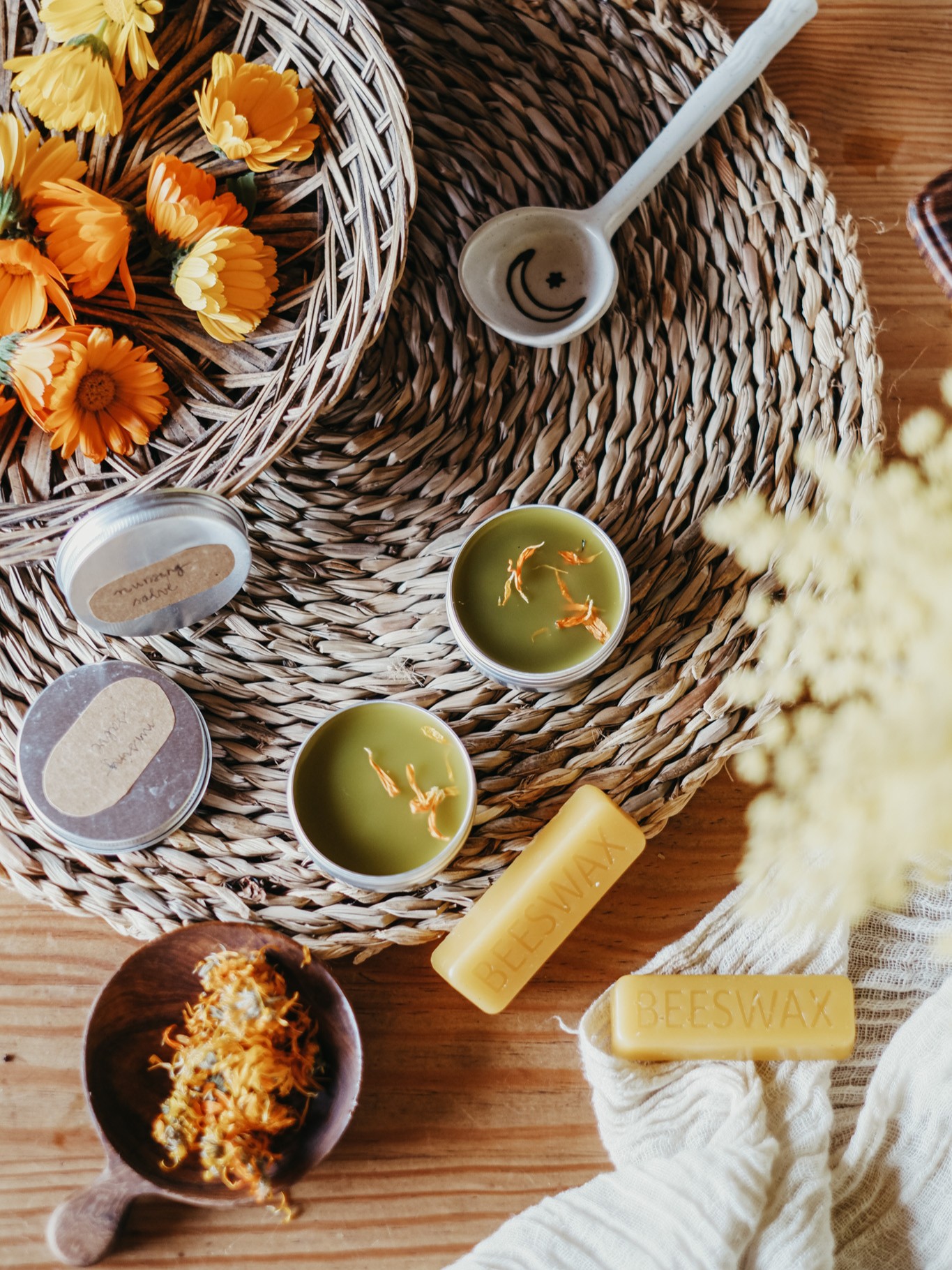 Calendula flowers, oil, and salve on a table - representing herbs covered in Herbal Academy's Holistic Approach for Tick-Borne Diseases Course. 