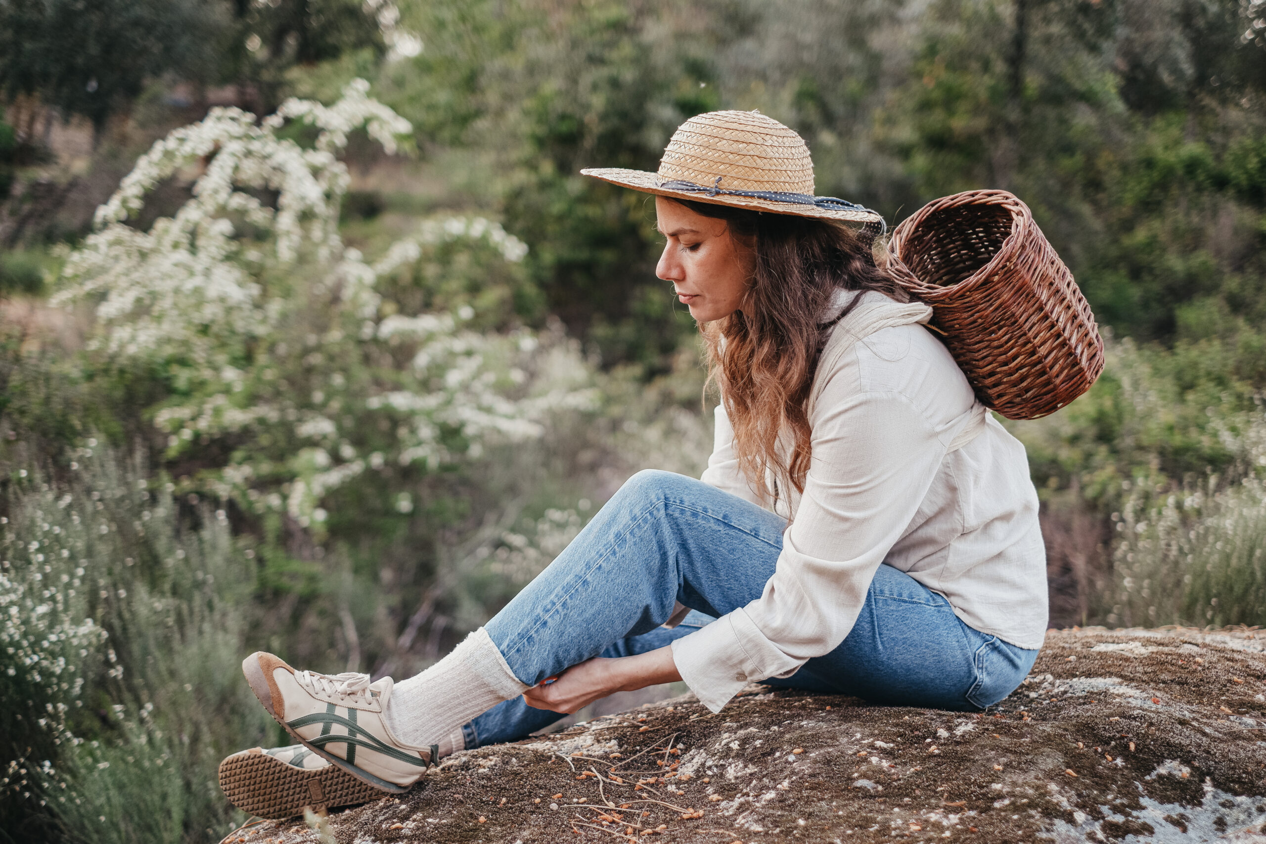 Woman tucking her jeans into her socks; a tick-bite prevention strategy covered in Herbal Academy's Holistic Approach for Tick-Borne Diseases Course. 