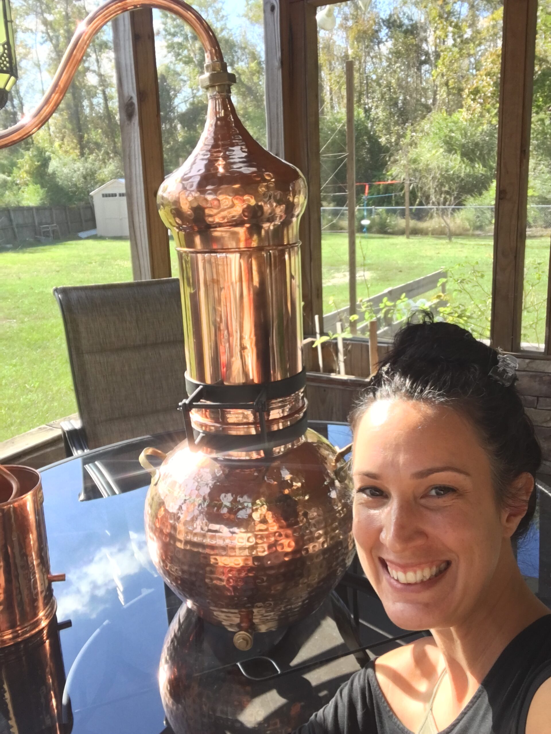 Rae in front of a distillation machine