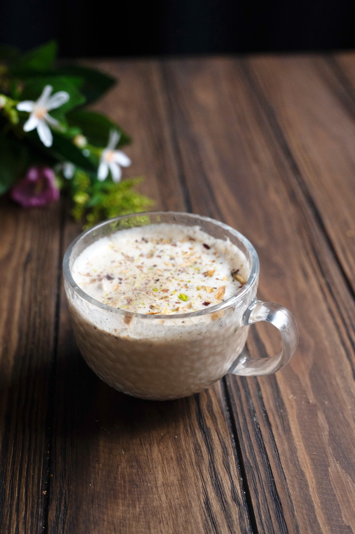 orange blossom latte in a glass mug on a wooden table