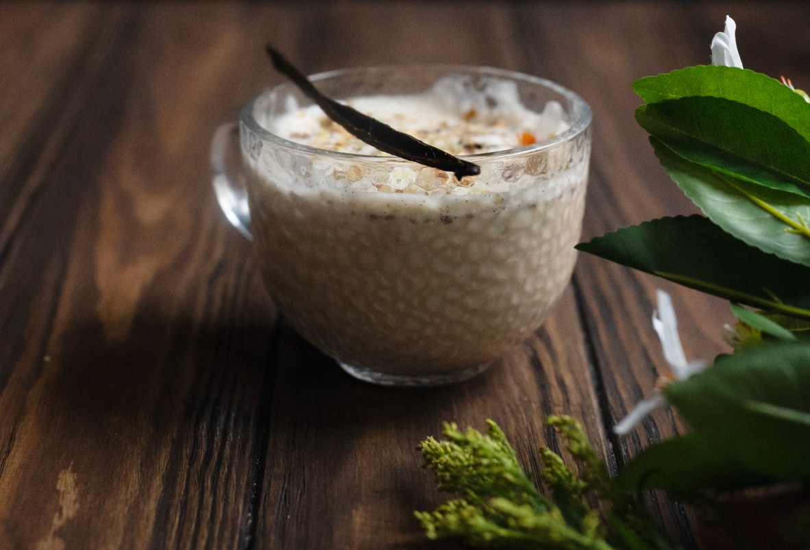 orange blossom latte with a vanilla pod across the top of the glass mug
